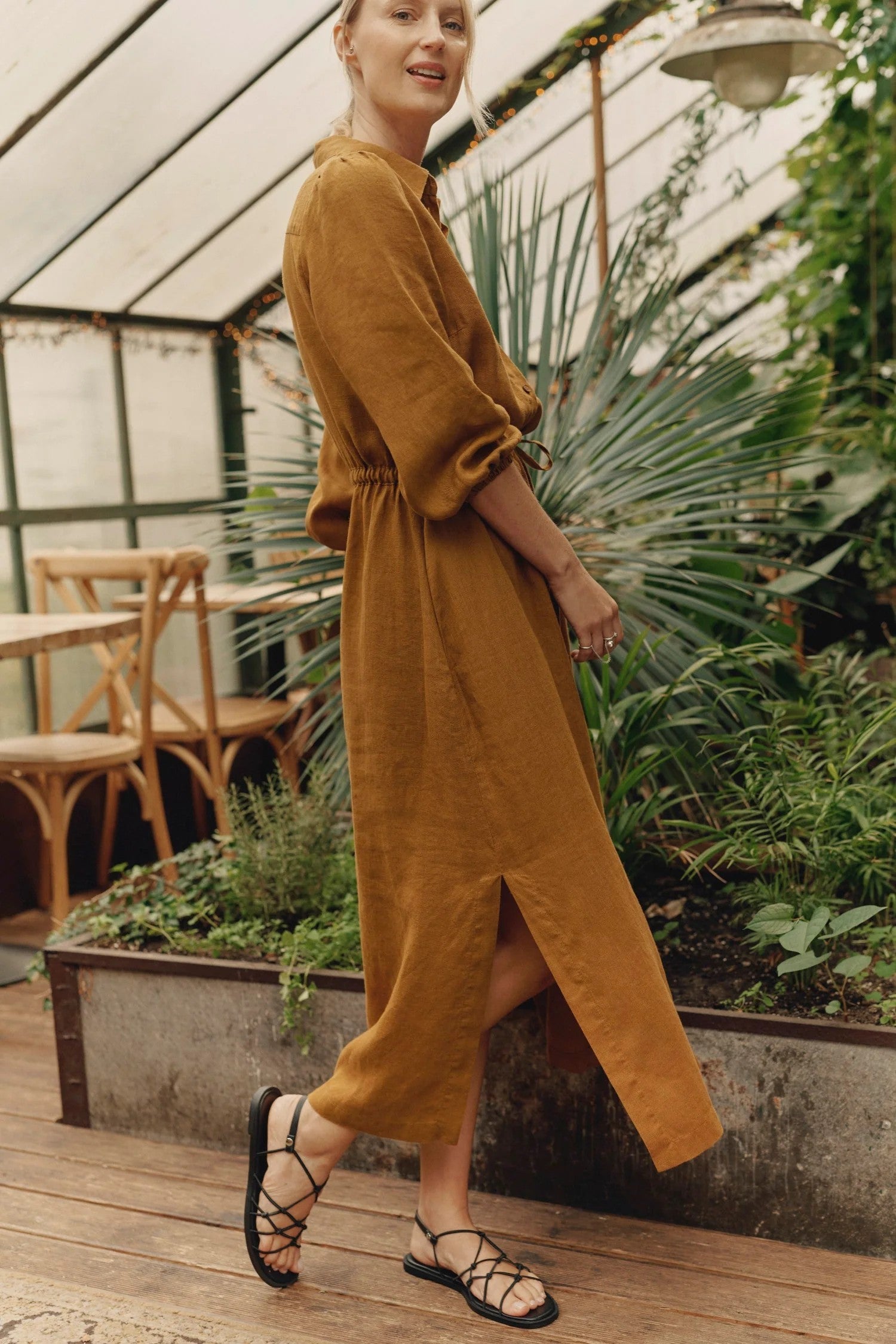 elegant bronze linen dress with side slits and a drawstring belt, captured in soft afternoon light