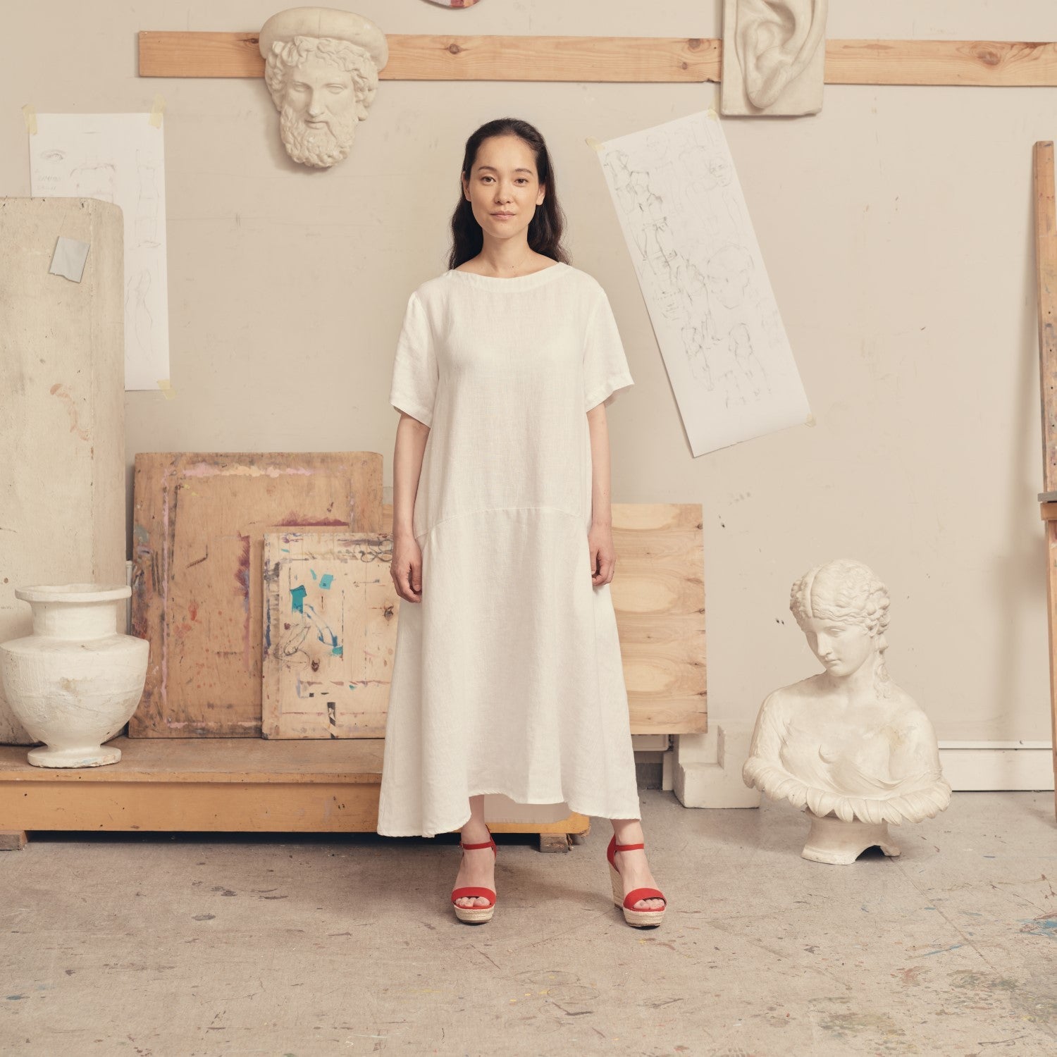 confident woman in a bold white linen dress with back buttons and pockets