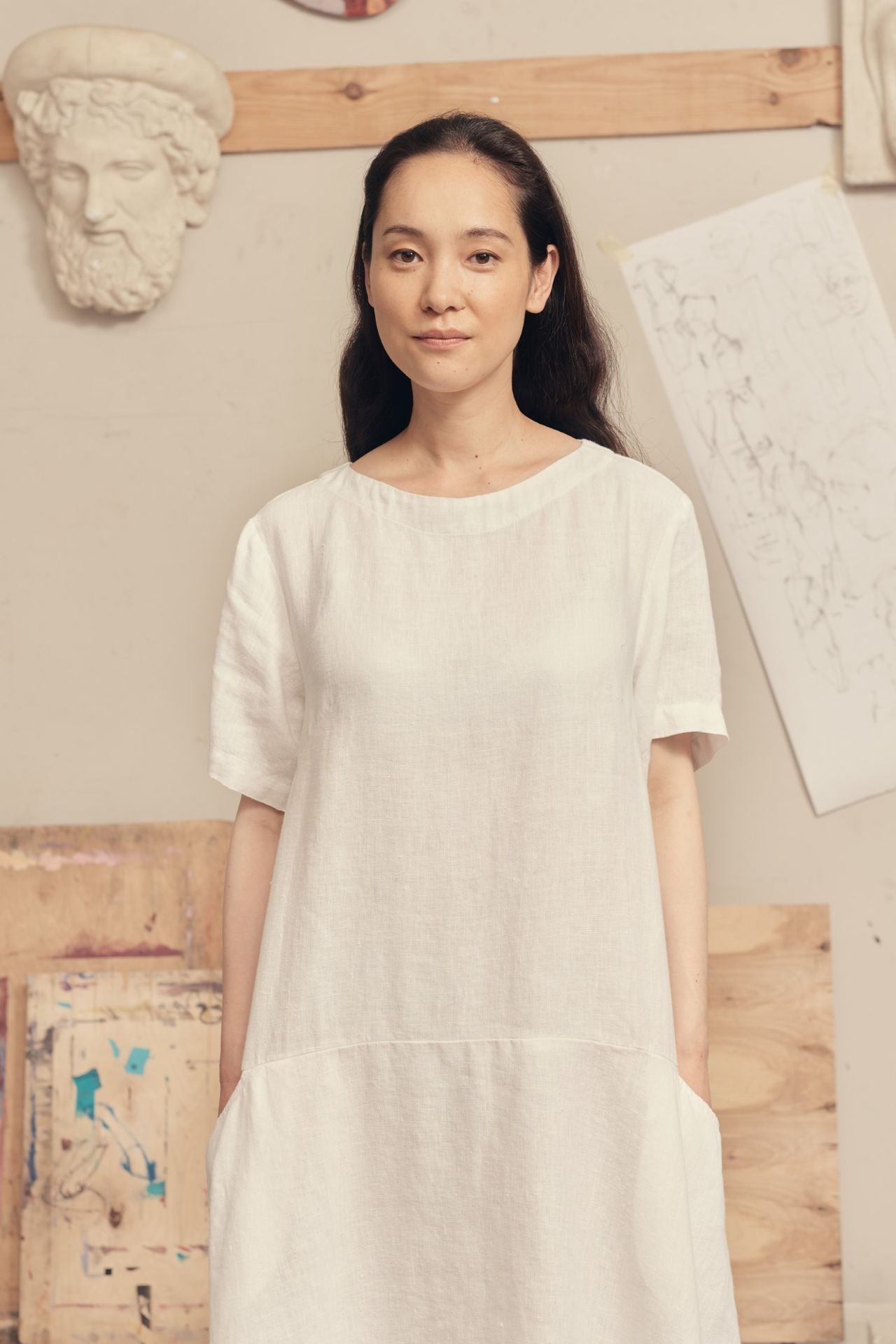elegant white linen dress with a-line silhouette and back button closure, captured in soft natural light