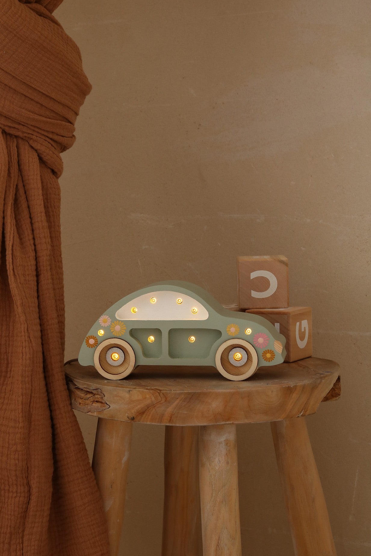 playful beetle car lamp glowing warmly on a pinewood nightstand beside a storybook
