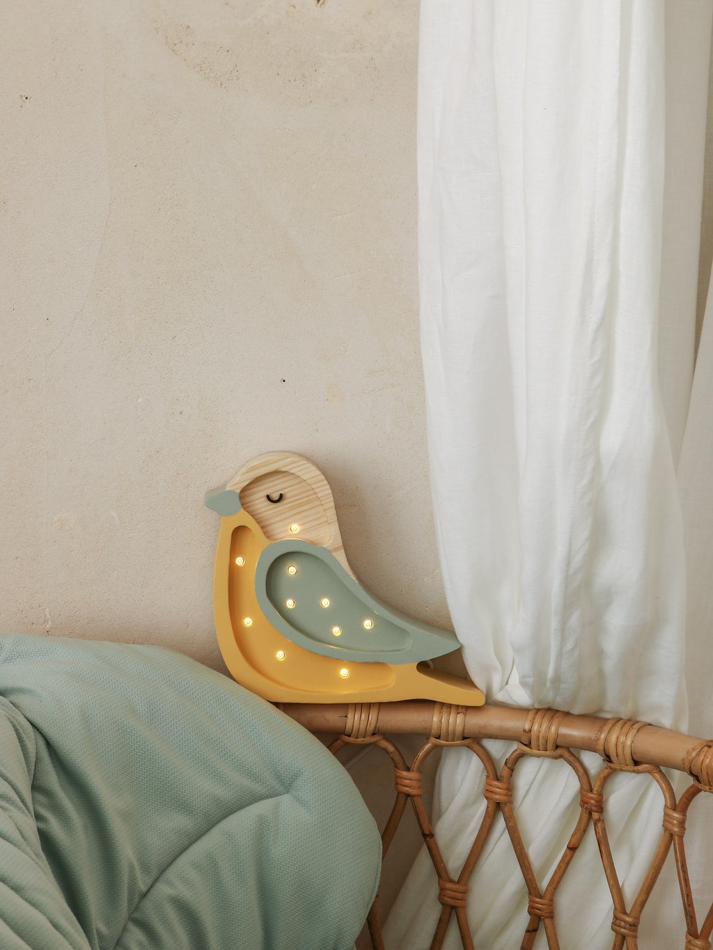 playful little lights bird lamp glowing warmly on a child's bedside table