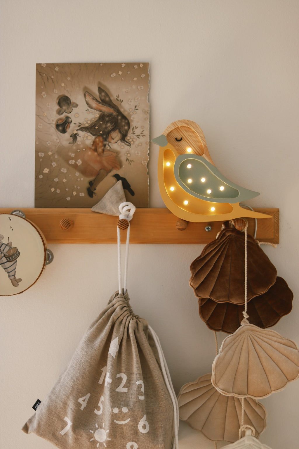 handmade pine wood bird lamp casting a warm glow on a nursery shelf