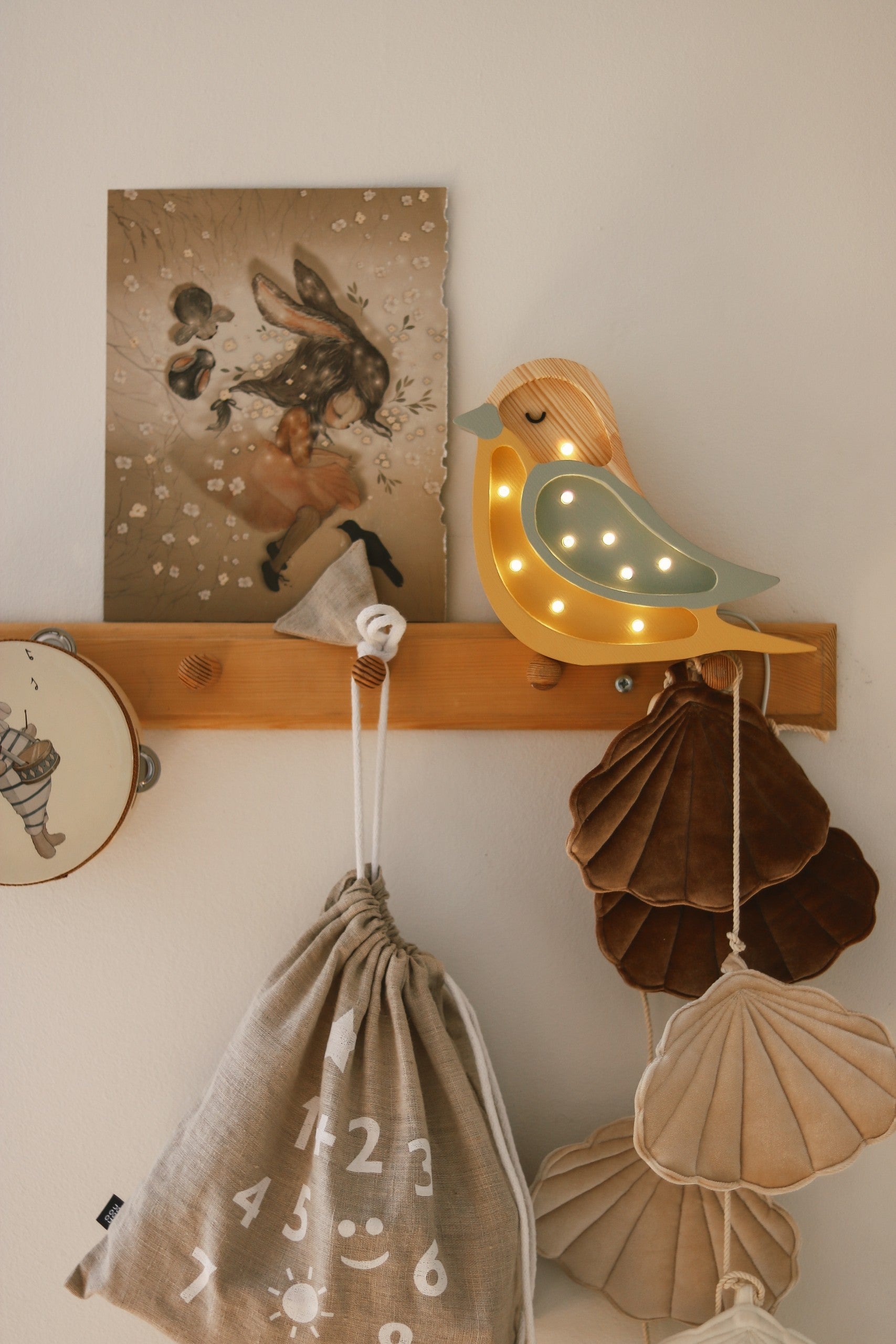 handmade pine wood bird lamp casting a warm glow on a nursery shelf