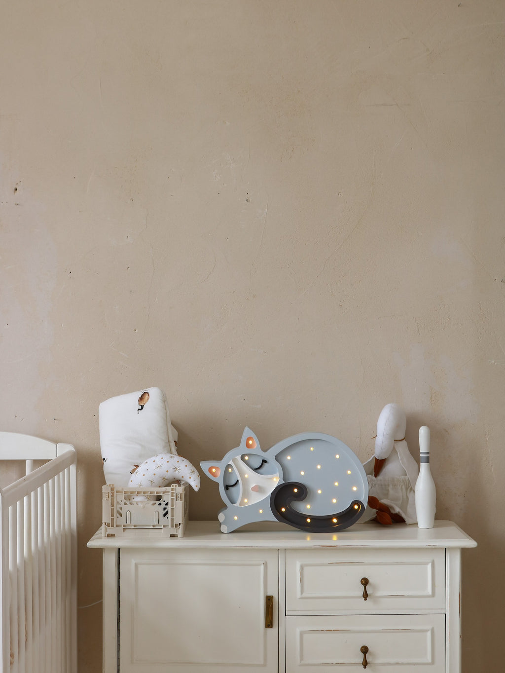 bold little lights cat lamp glowing warmly on a dark wood nightstand