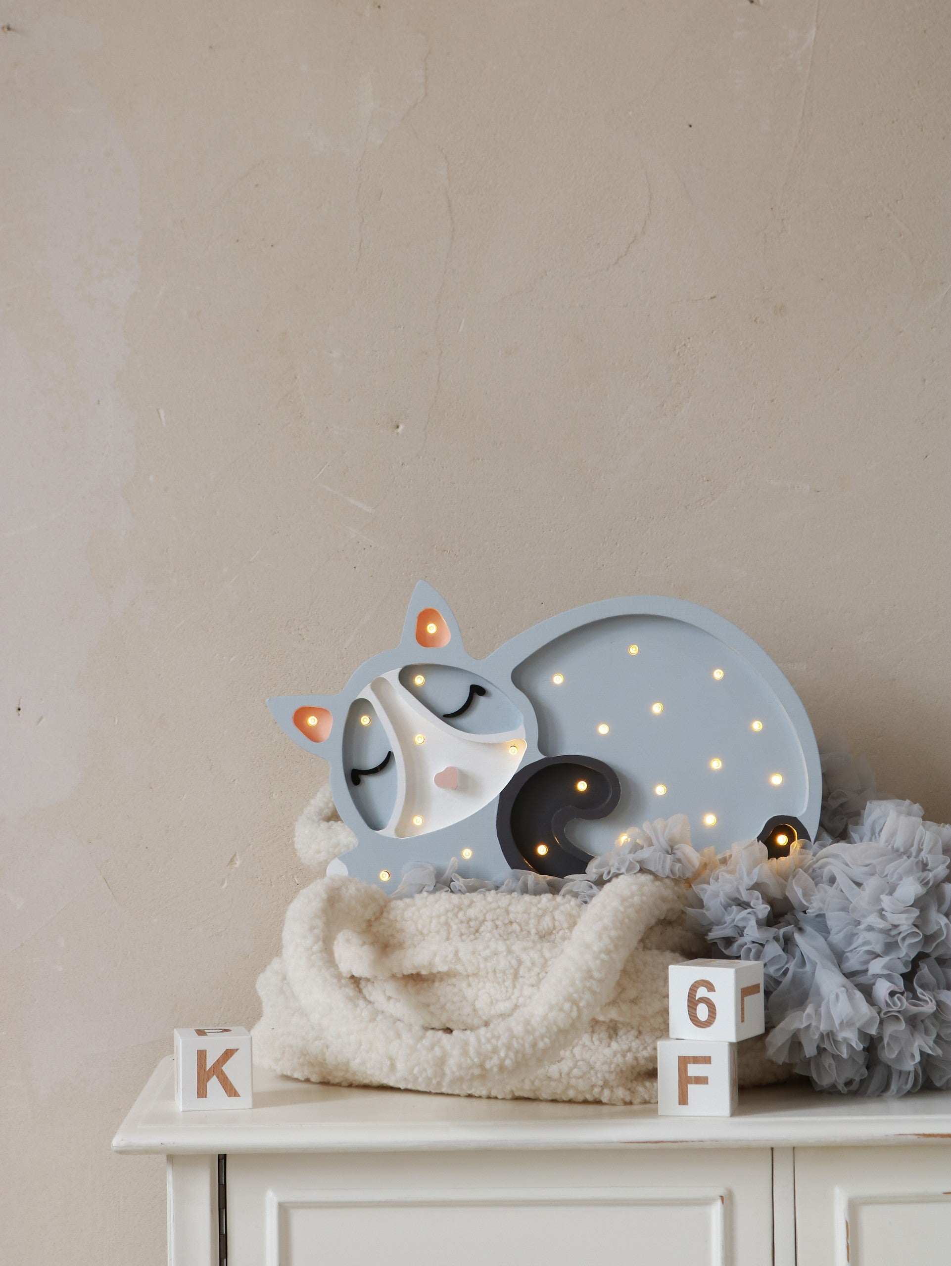 little lights cat lamp casting a soft glow on a wooden nightstand