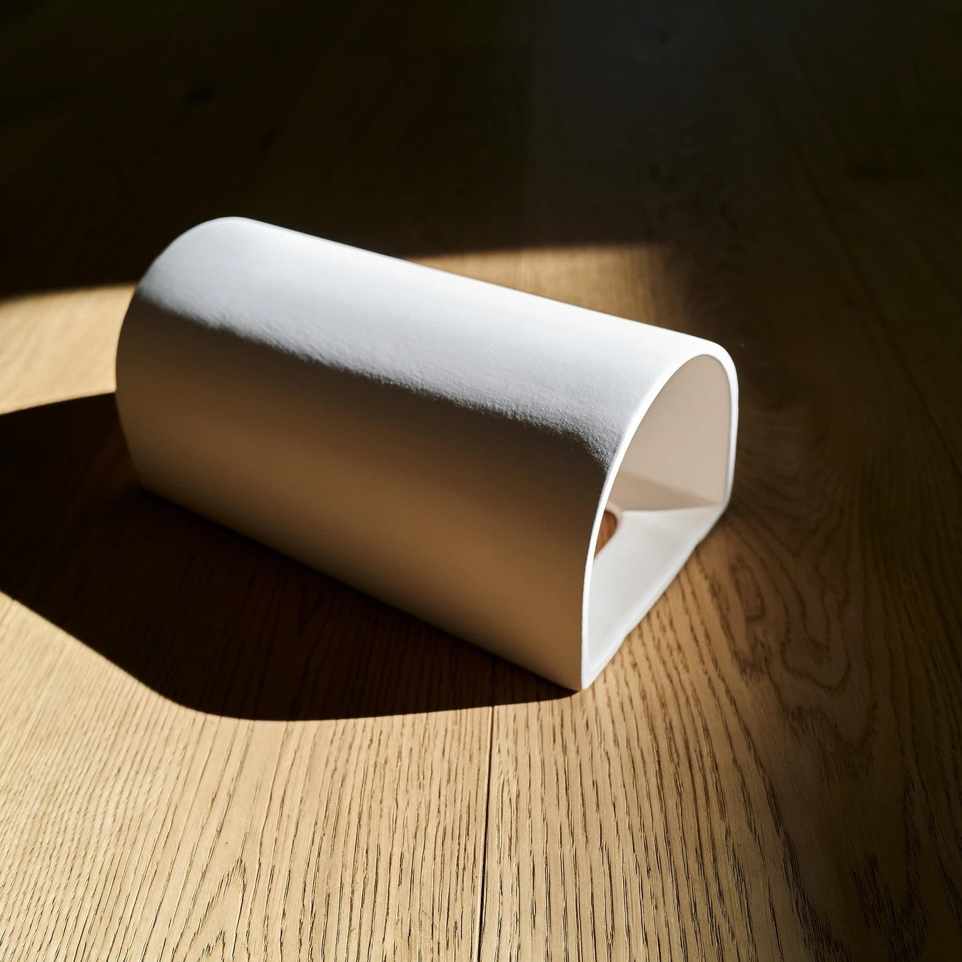 elegant white ceramic wall sconce casting a soft, refined glow in a curated interior