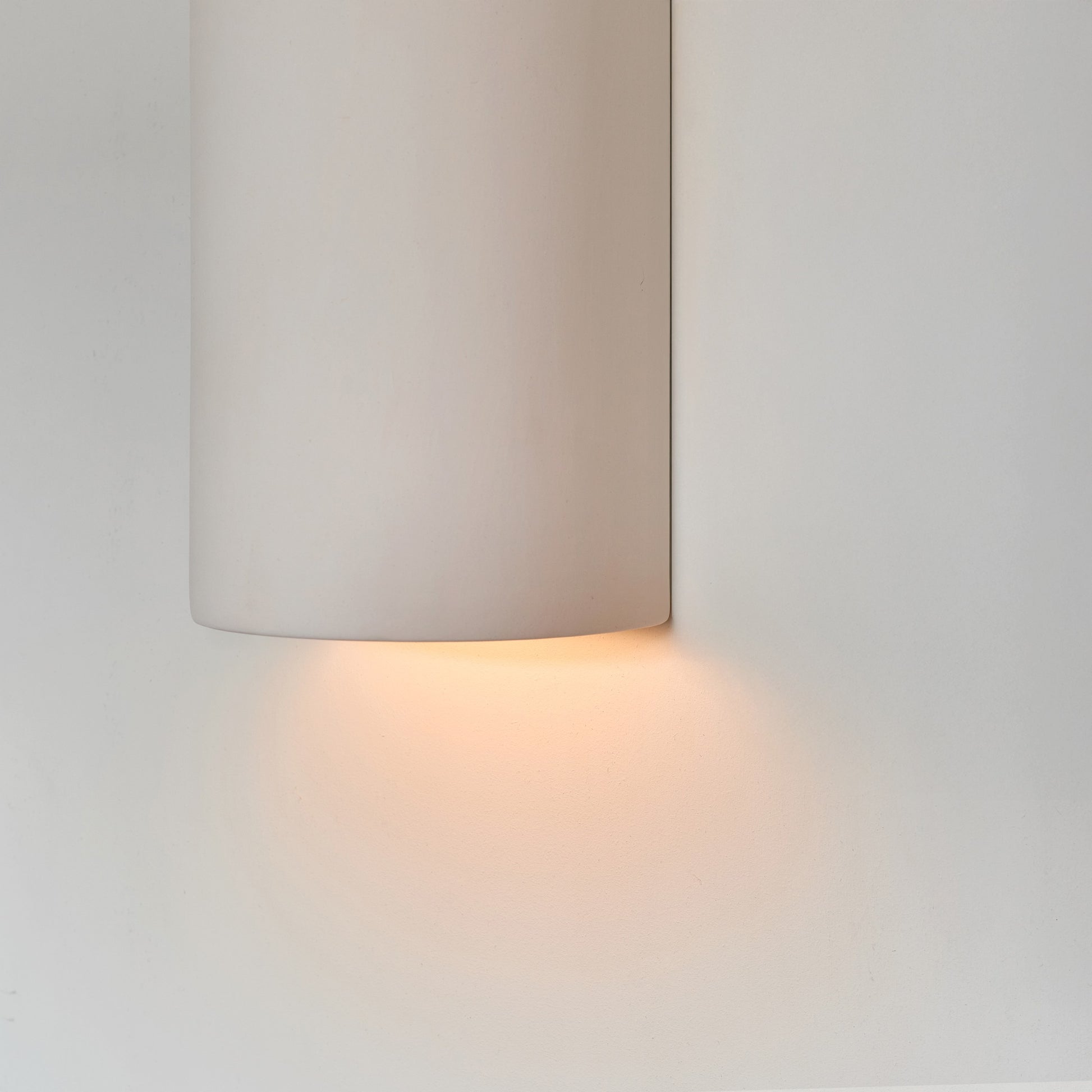 a softly glowing white ceramic wall sconce casting a warm, comforting glow in a nursery