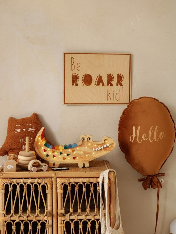 softly lit handcrafted crocodile lamp casting a warm glow on a nursery shelf