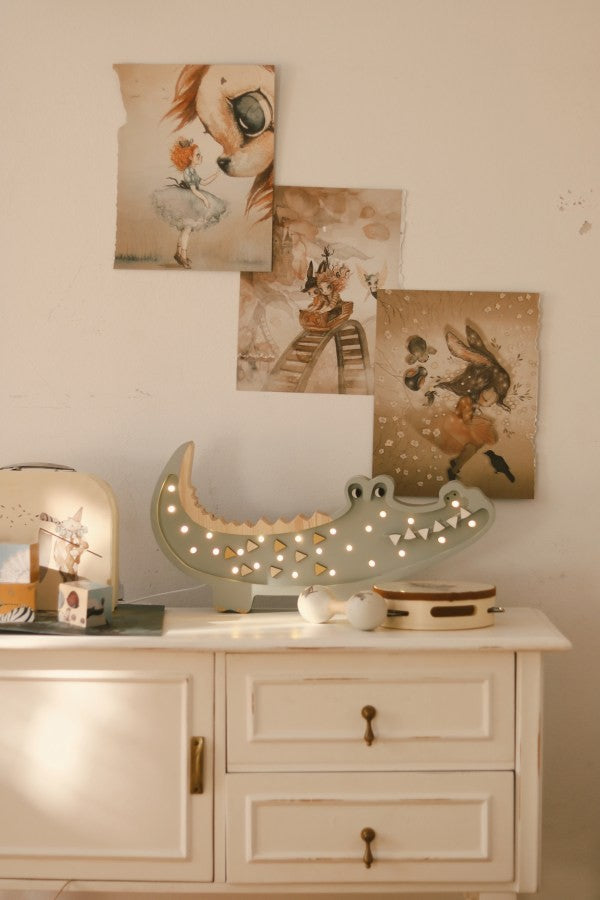 elegant close-up of a handcrafted pine crocodile lamp with warm led glow on a refined nursery shelf