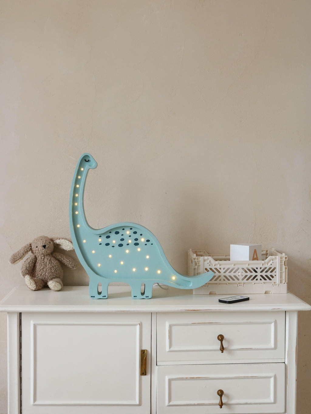 diplodocus lamp with remote control and dimmer settings on a nightstand