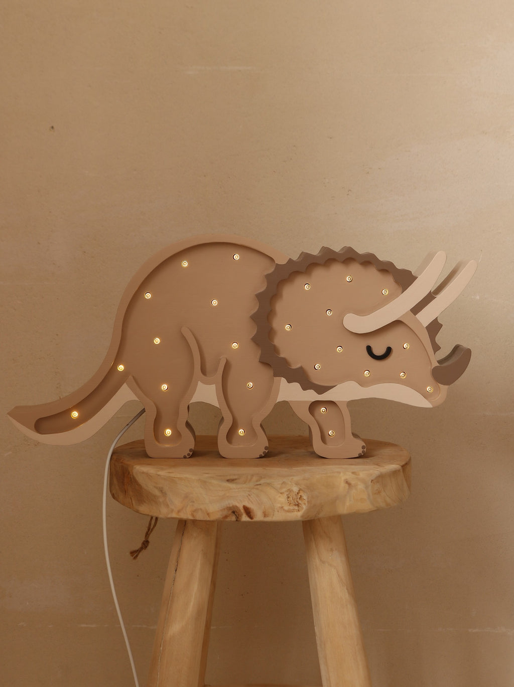 softly lit triceratops night light casting a warm, comforting glow on a nursery shelf