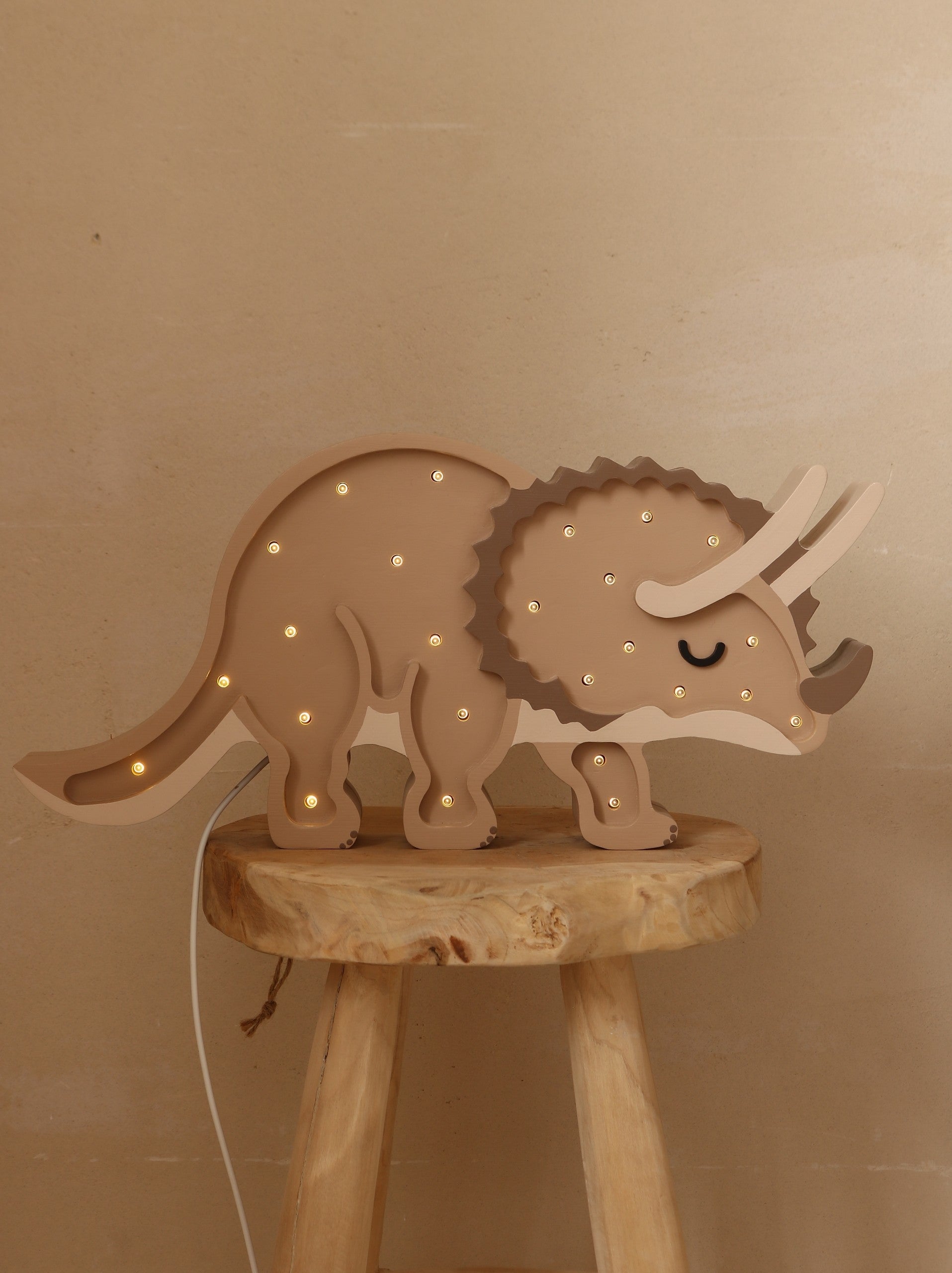 softly lit triceratops night light casting a warm, comforting glow on a nursery shelf