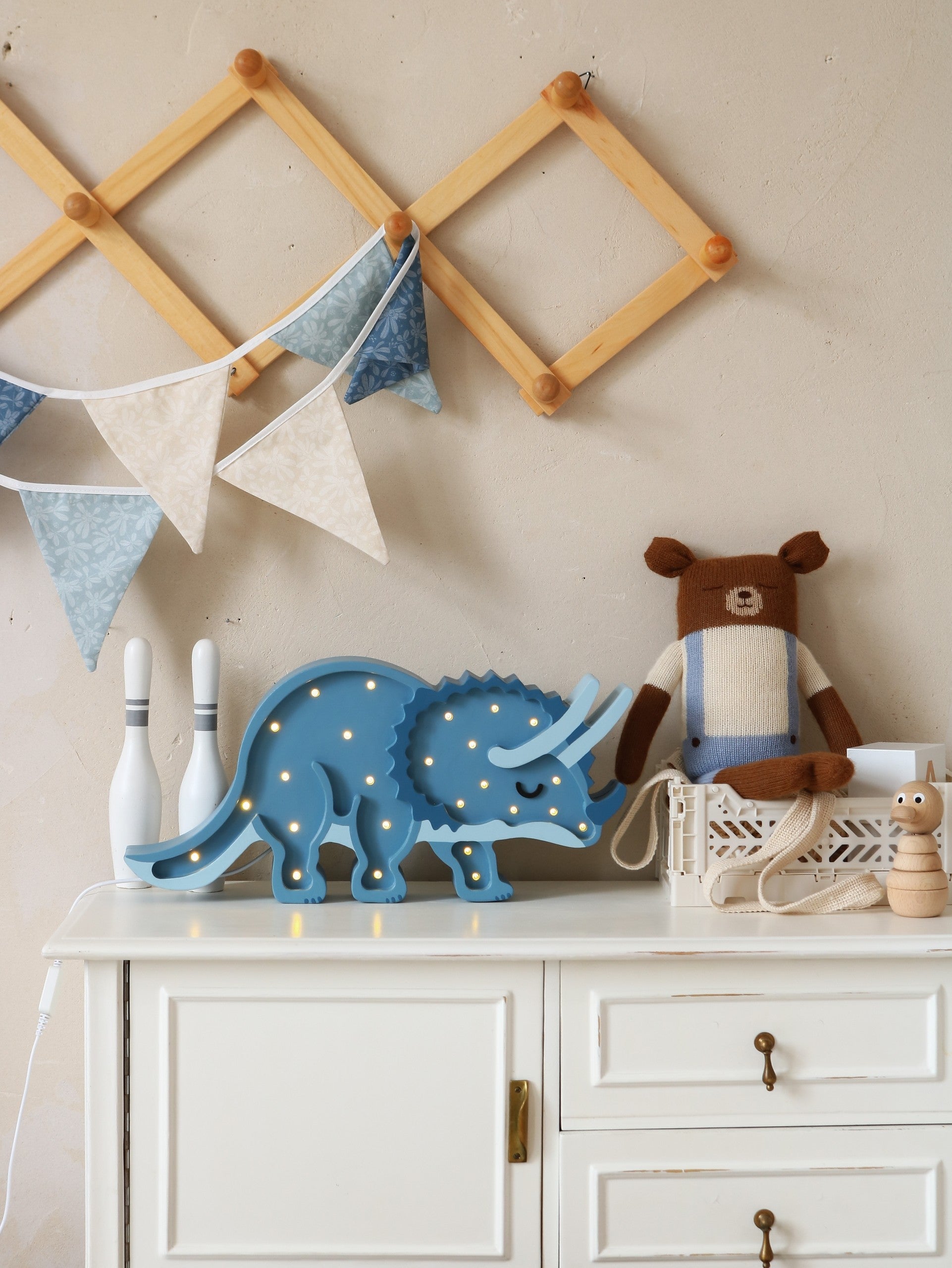 playful triceratops lamp casting a warm glow on a childs bedside table