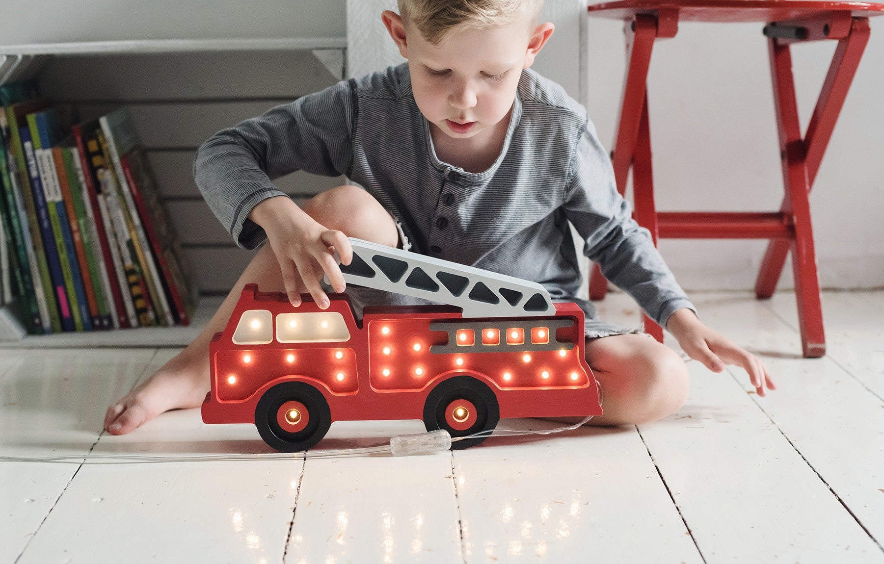 elegant pine wood firetruck lamp casting a warm, refined glow in a child's room