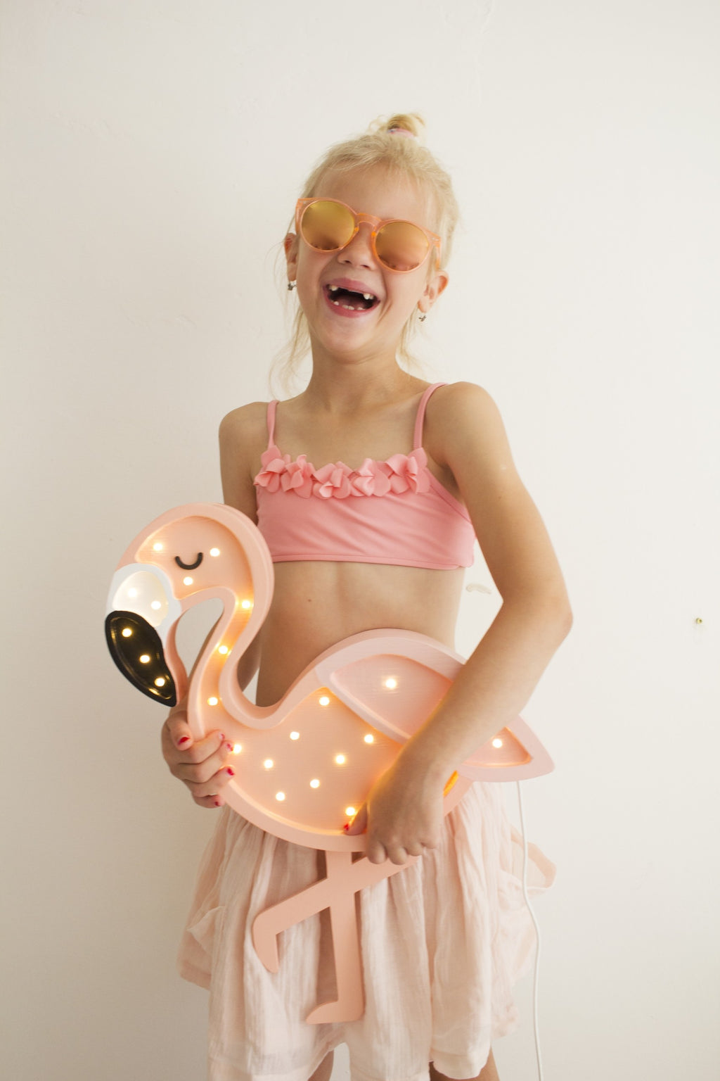 elegant profile of a handcrafted pine flamingo lamp casting a soft warm glow in a refined nursery