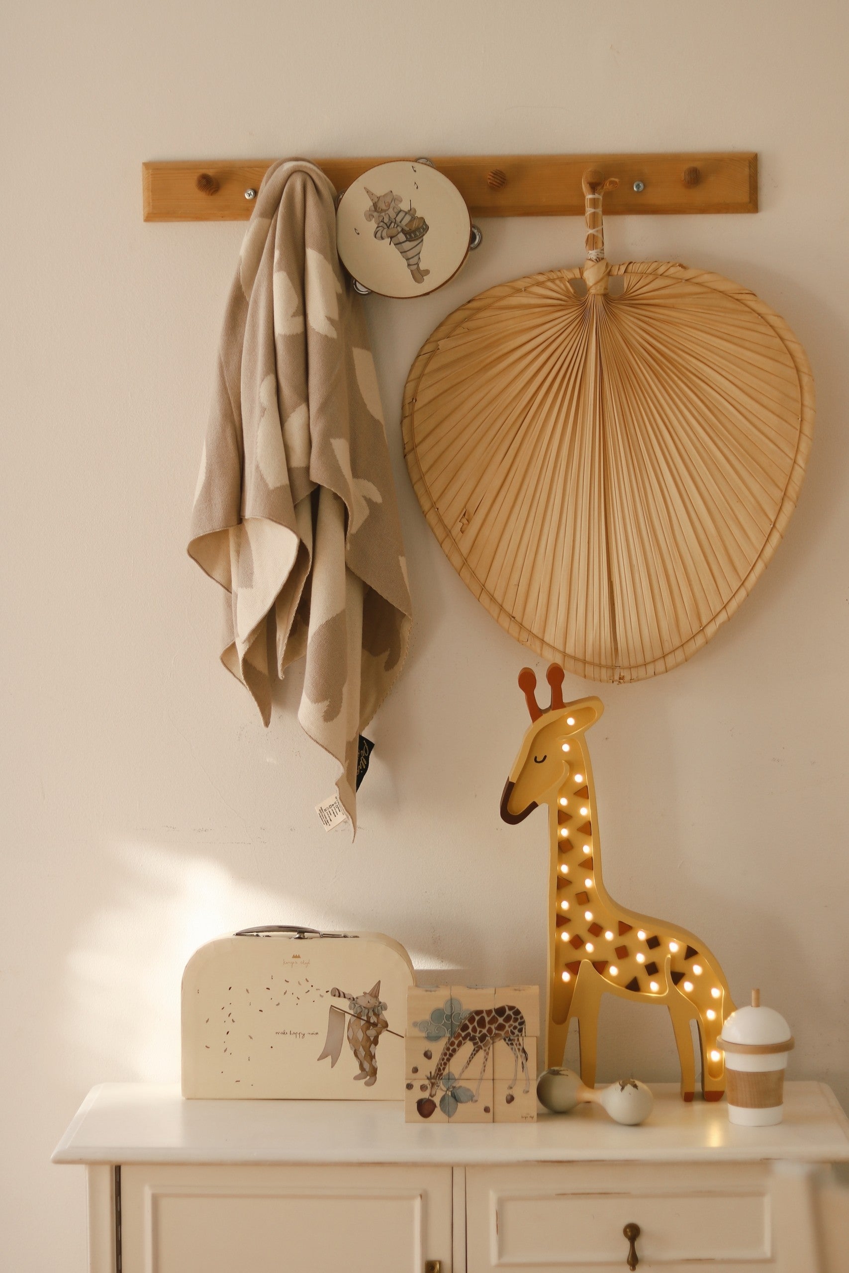 handcrafted pinewood giraffe lamp casting a soft warm glow on a nursery shelf