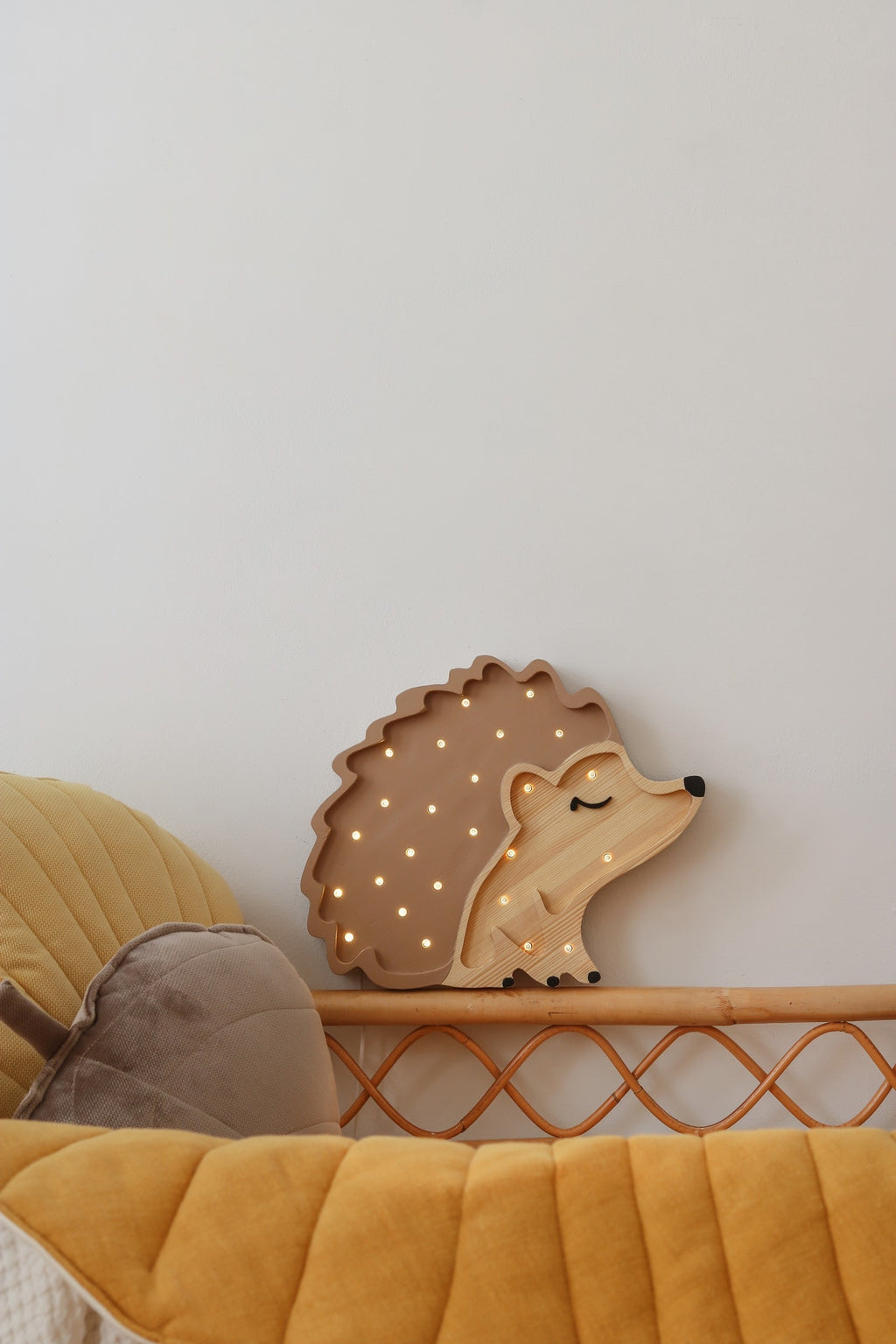 a soft glow from the handcrafted pine hedgehog night lamp on a bedside table