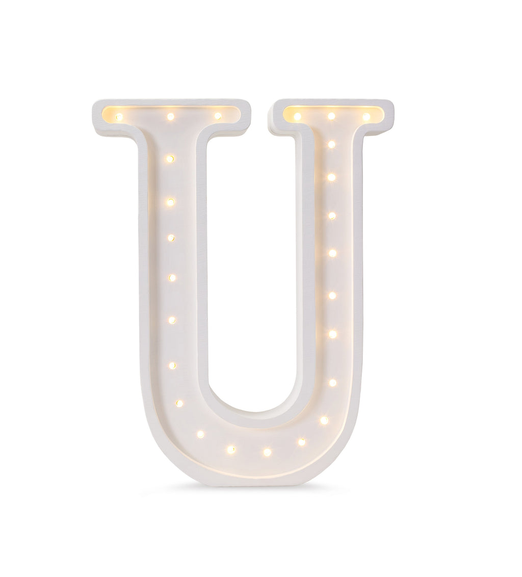 handcrafted wooden u letter lamp casting a soft warm glow on a nursery shelf