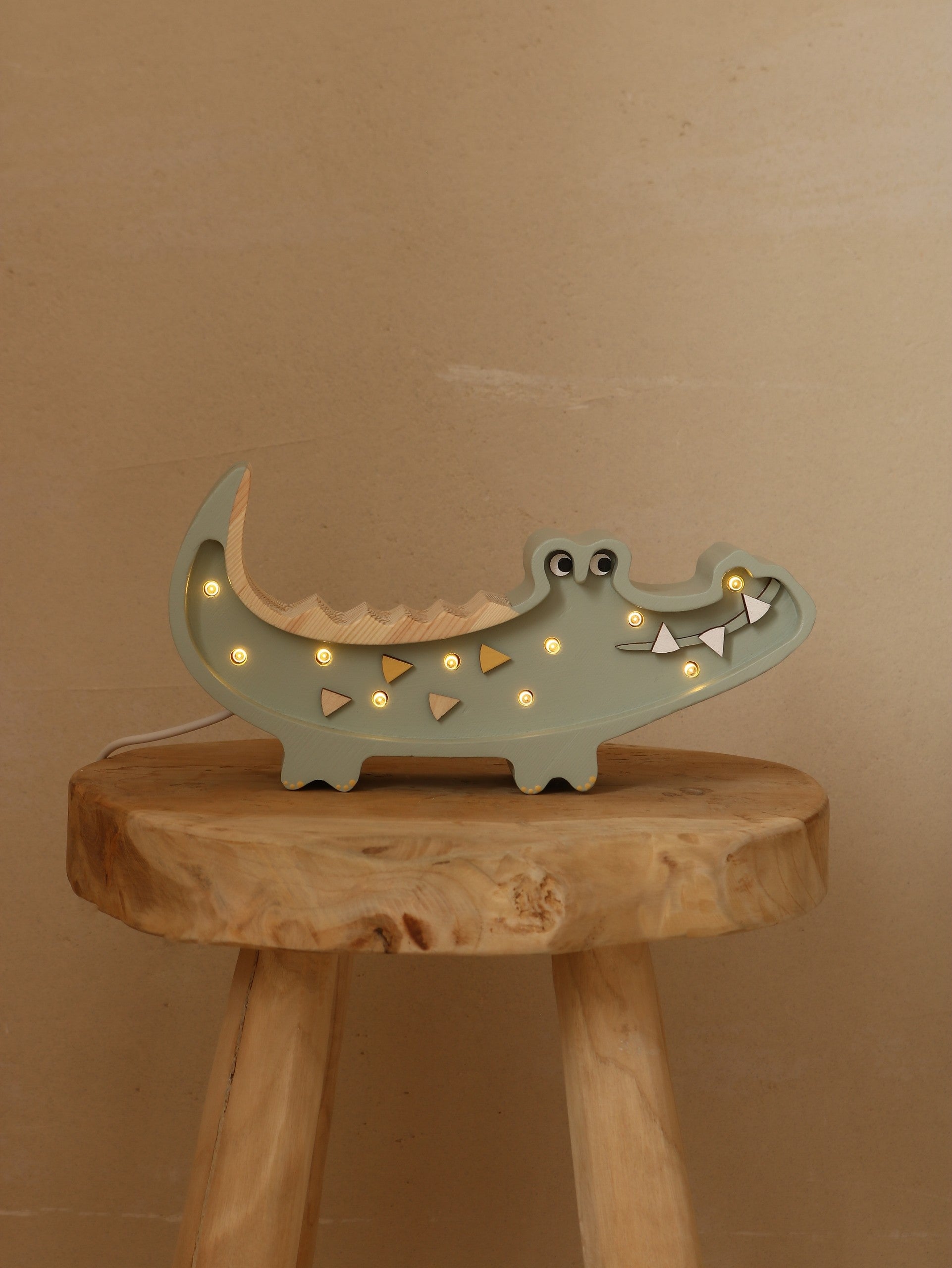 close-up of the crocodile lamp's dimmer switch and remote control on a pine wood nightstand