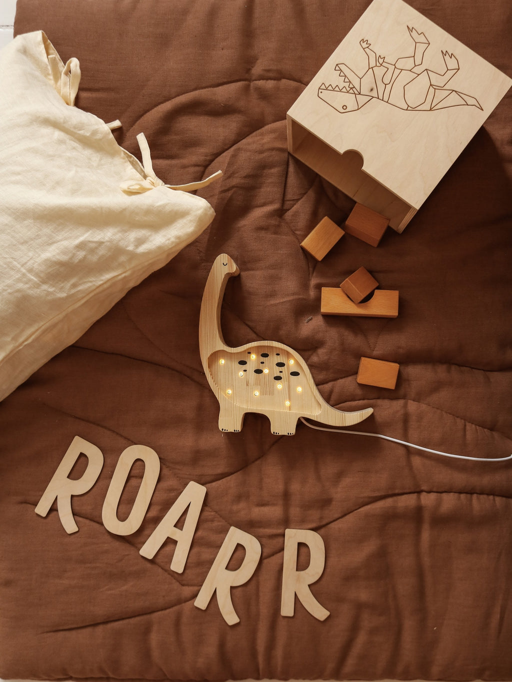 elegant solid pinewood mini dino lamp casting a refined warm glow in a sophisticated nursery setting