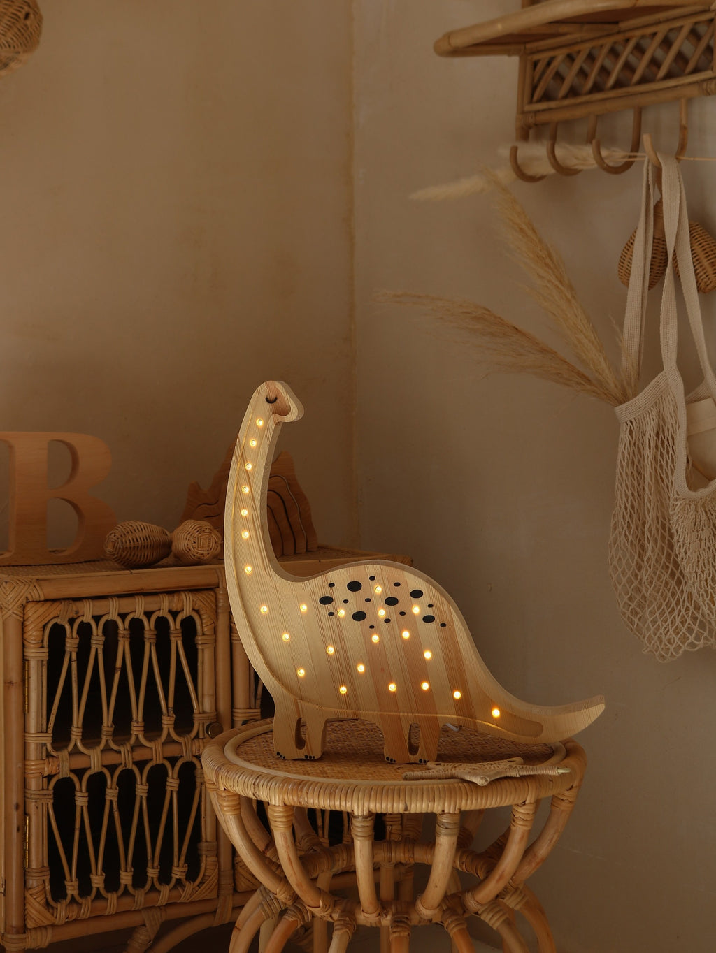 mini dino lamp casting a warm glow on a child's bedside table at night