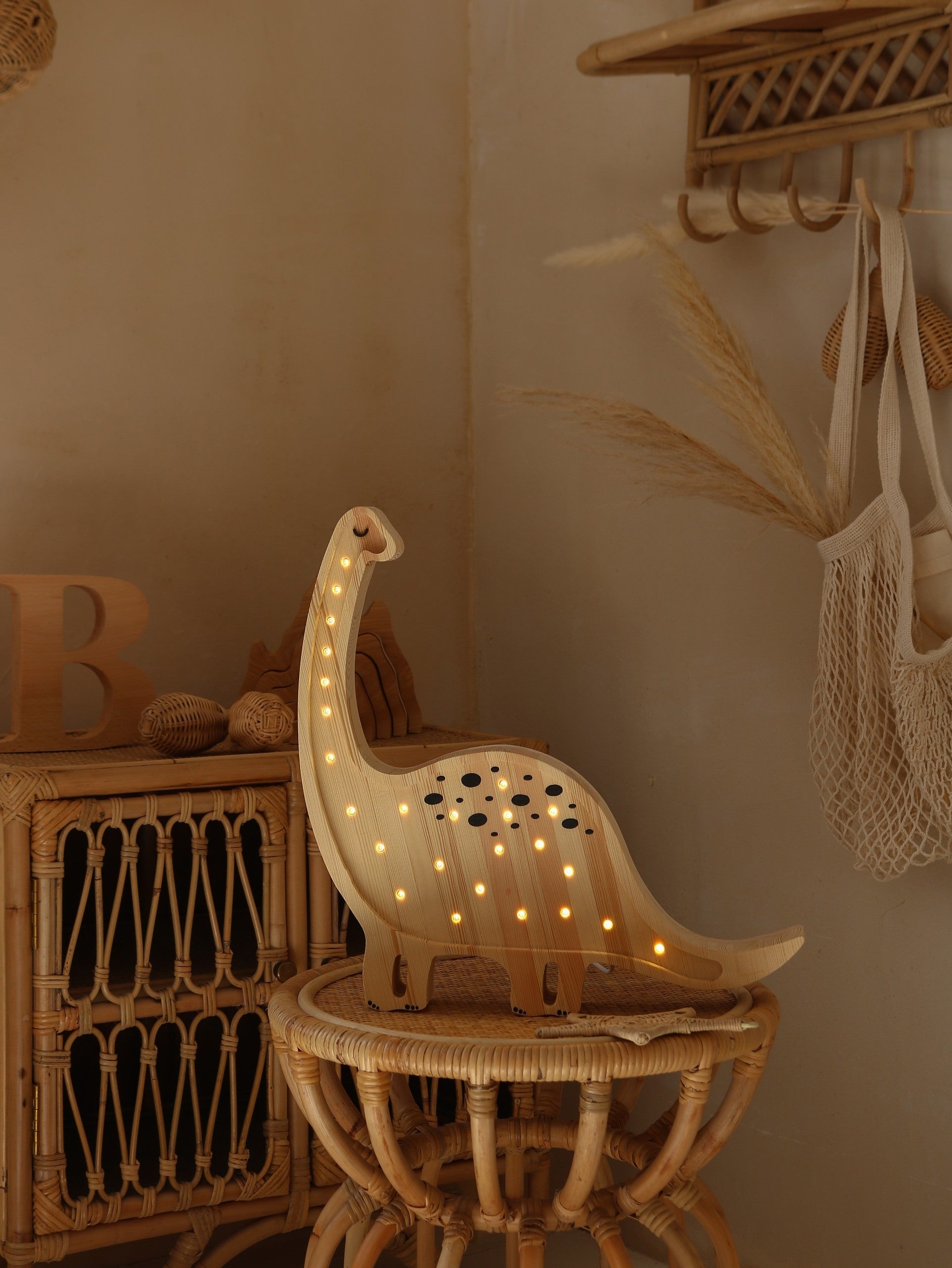 mini dino lamp casting a warm glow on a child's bedside table at night