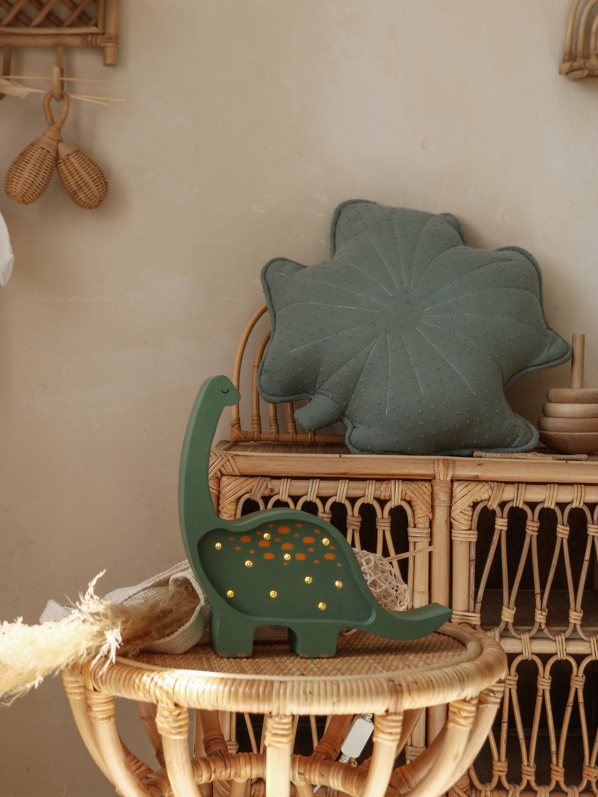 a child's hand gently turning the dimmer on a solid pinewood dino nightlight