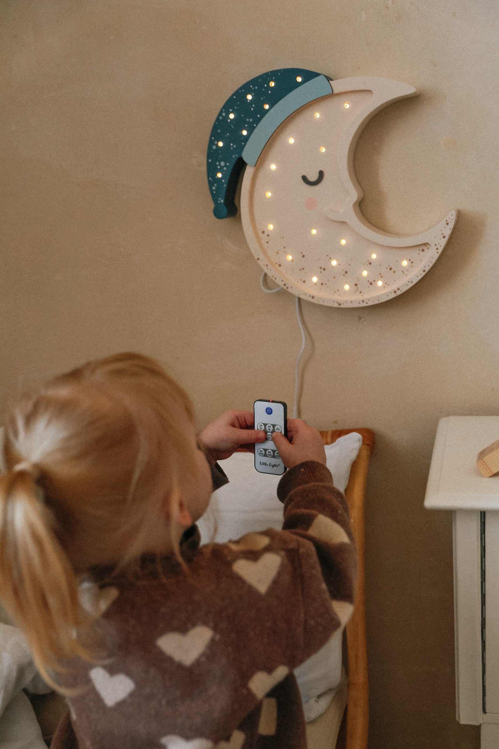 handcrafted pinewood moon lamp casting a soft glow on a childs bedside table