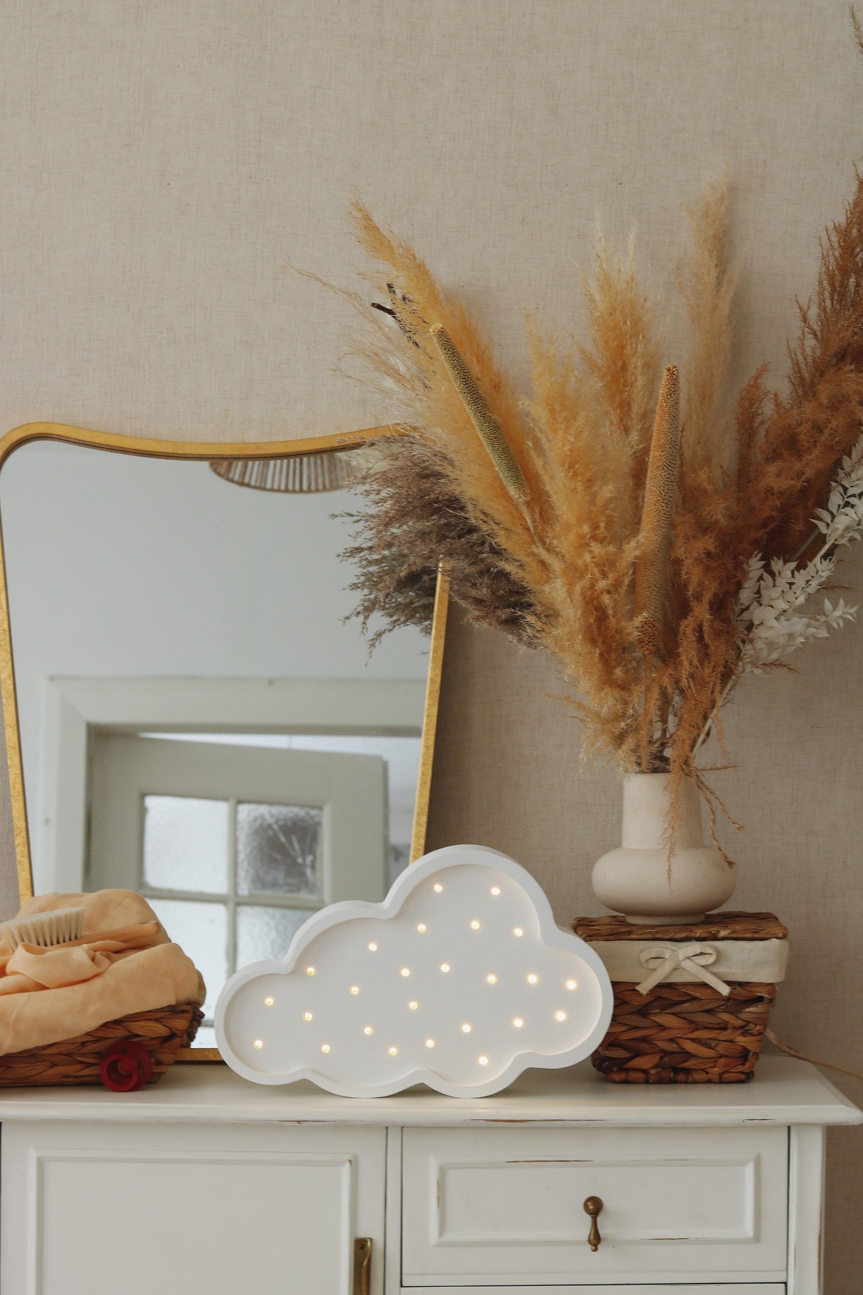 elegant handmade pine wood cloud lamp with a warm white glow on a refined nursery shelf