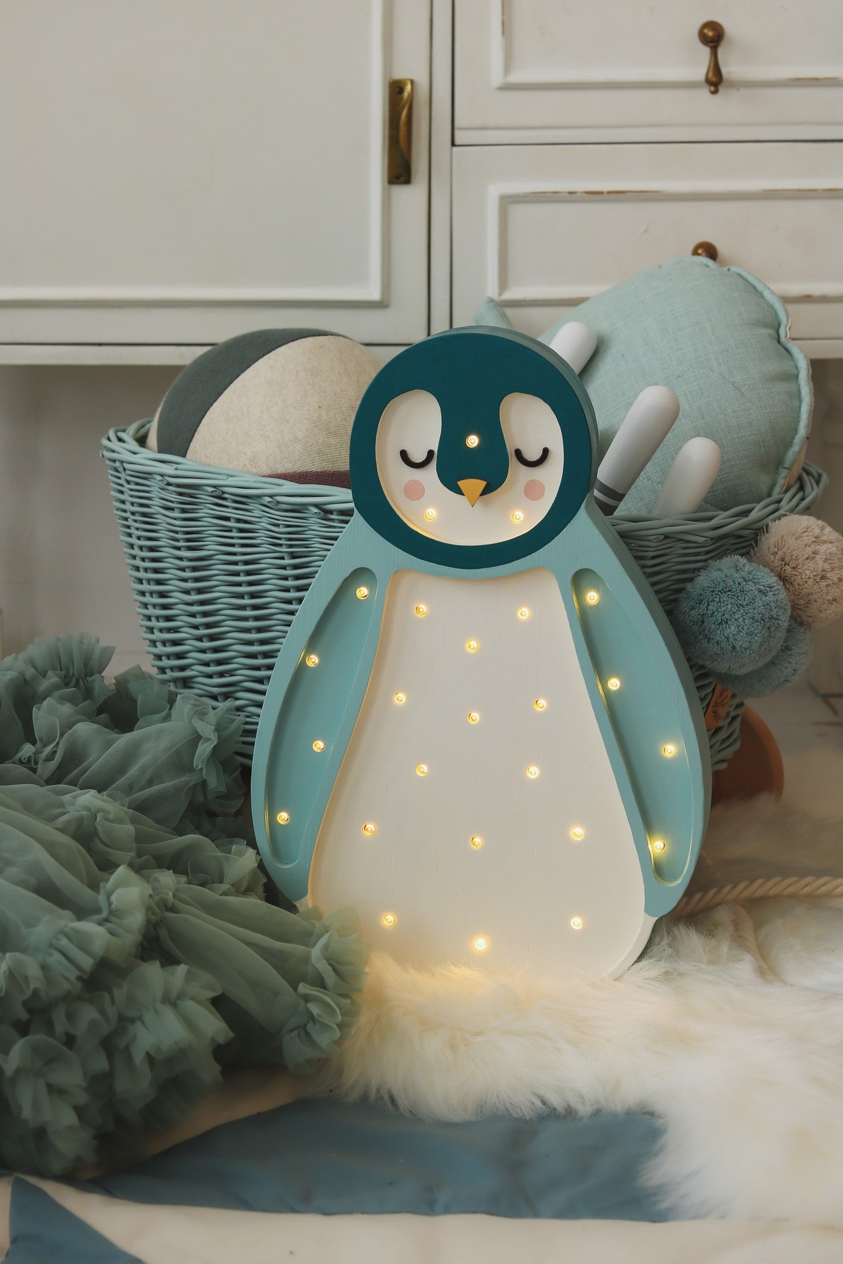 practical side view of a solid pinewood penguin lamp showing its warm led light and remote control