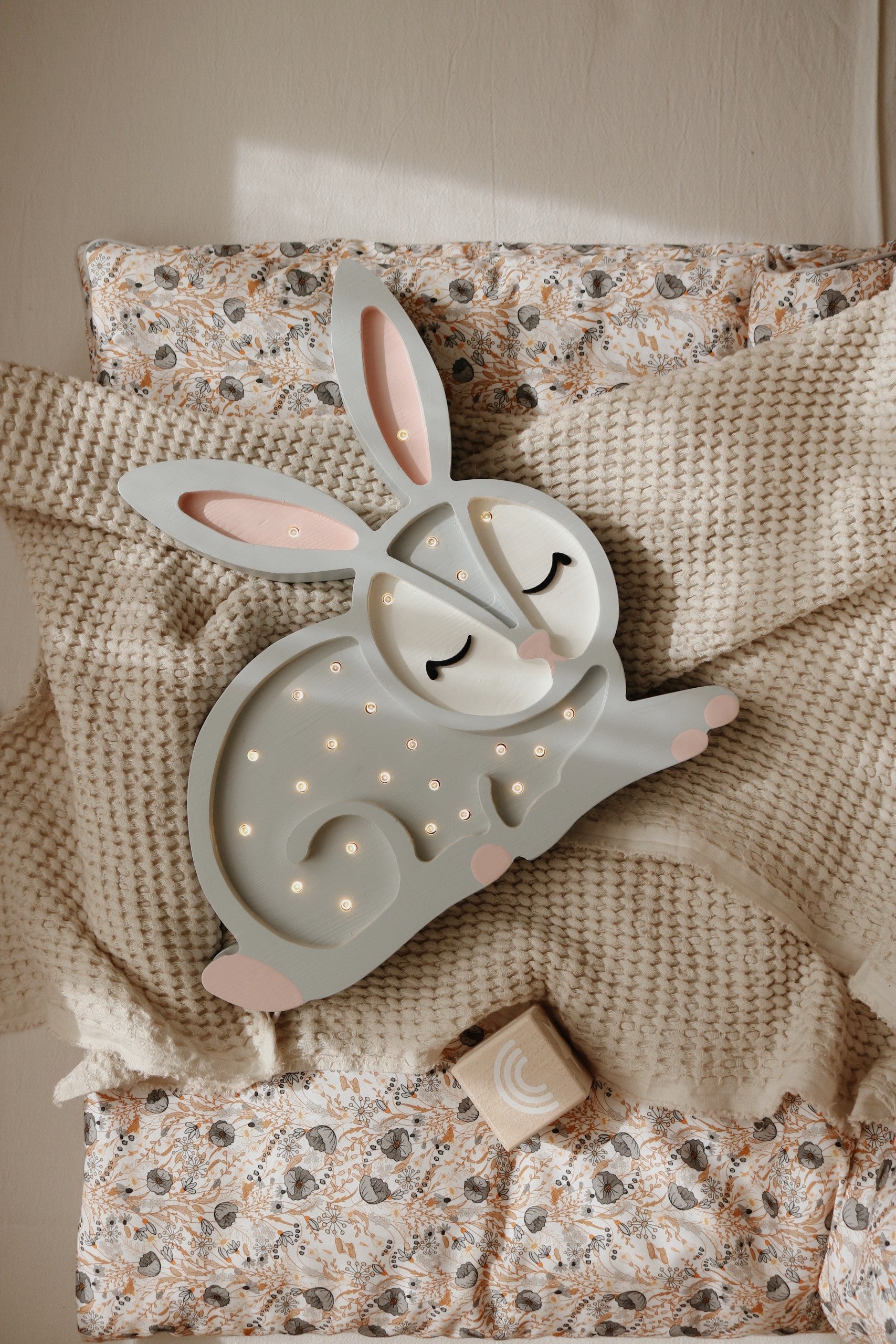 a playful bunny lamp casting a warm, magical glow on a childs bedside table