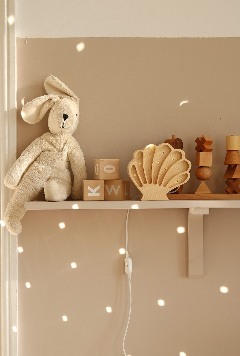 softly glowing wooden seashell lamp casting a warm, comforting glow in a child's cozy bedroom