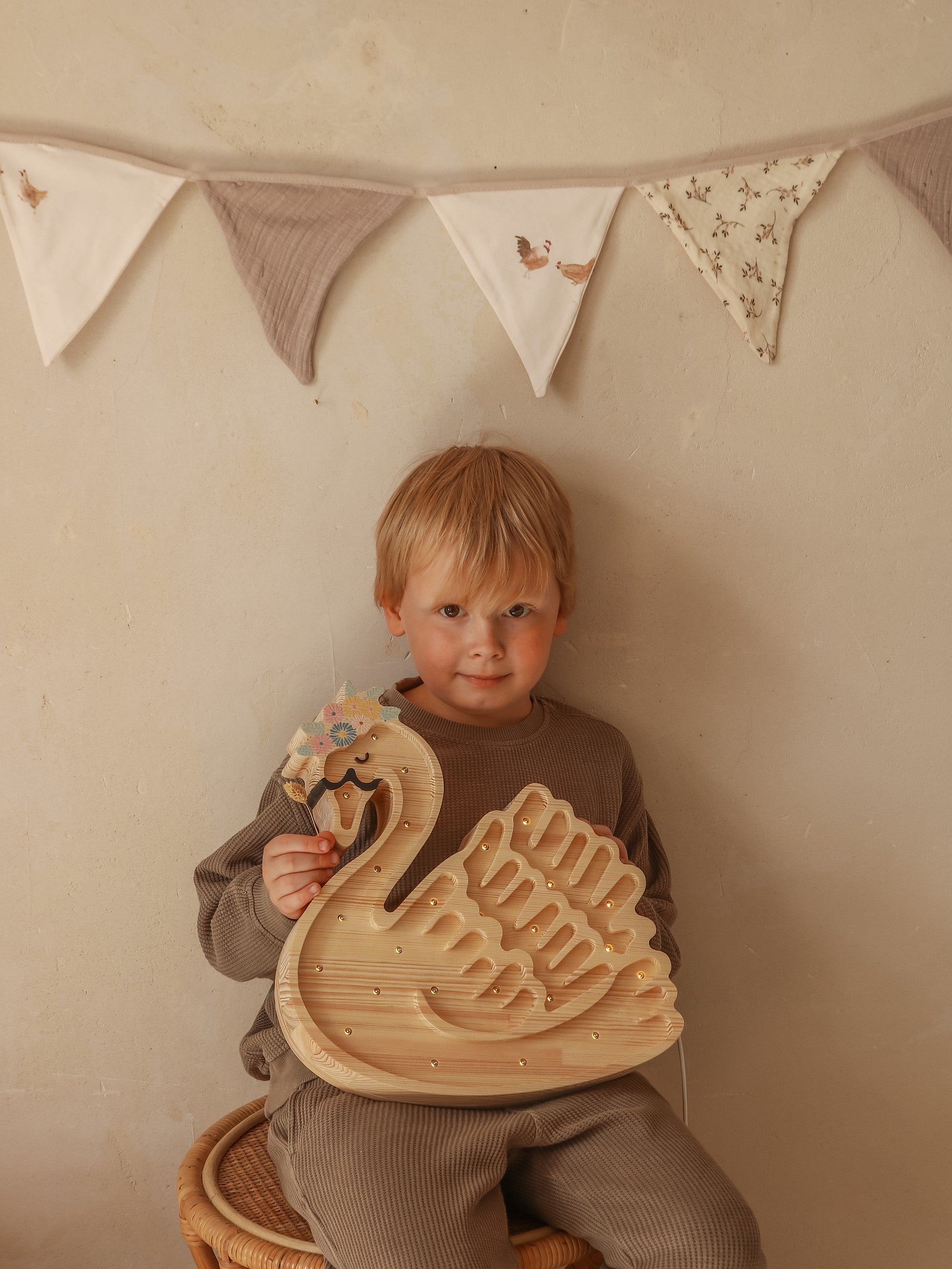 practical close-up of the swan lamp's dimmer switch and power cord on a pine wood nightstand