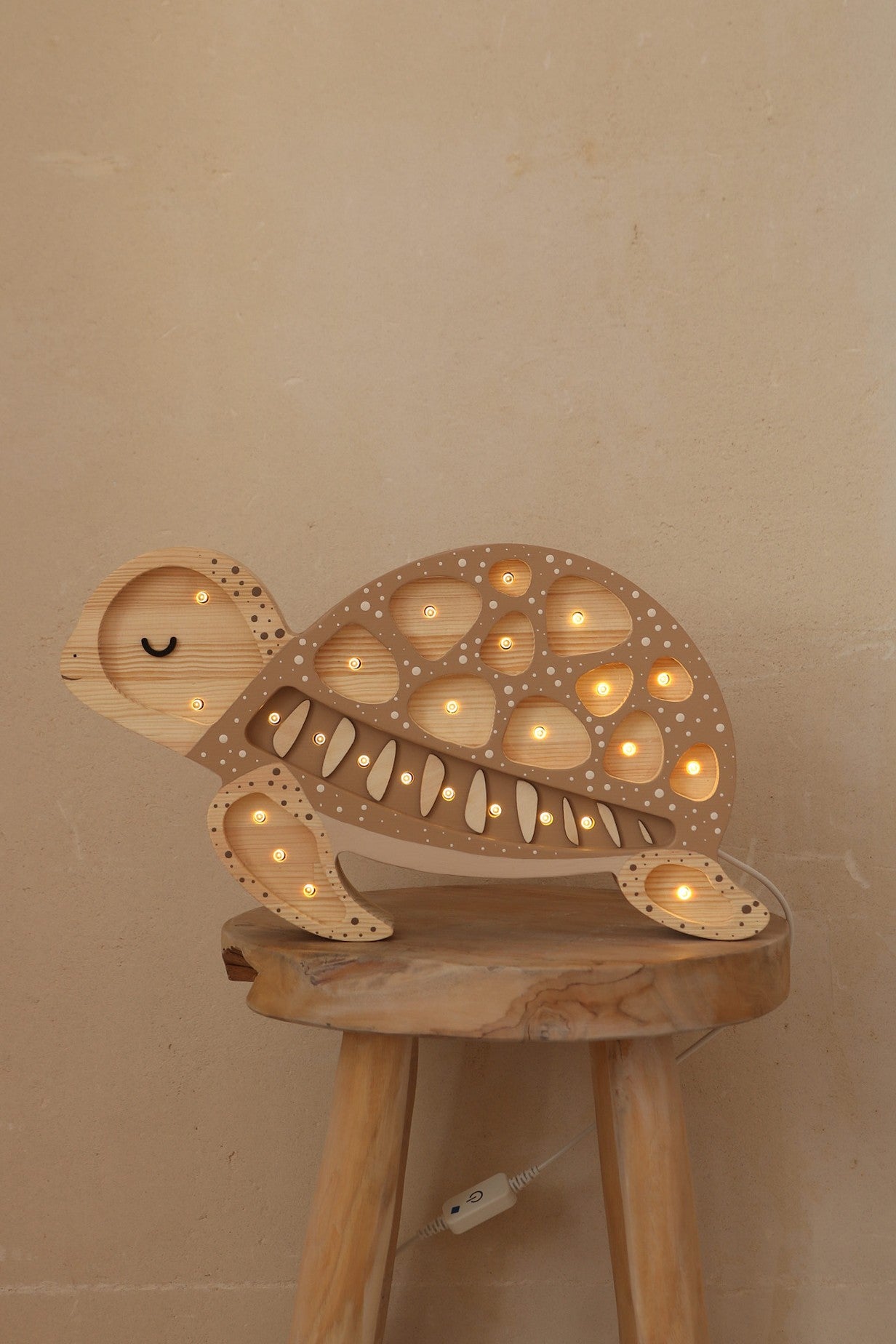 bold close-up of a handcrafted pine wood turtle lamp casting a warm, confident glow in a nursery