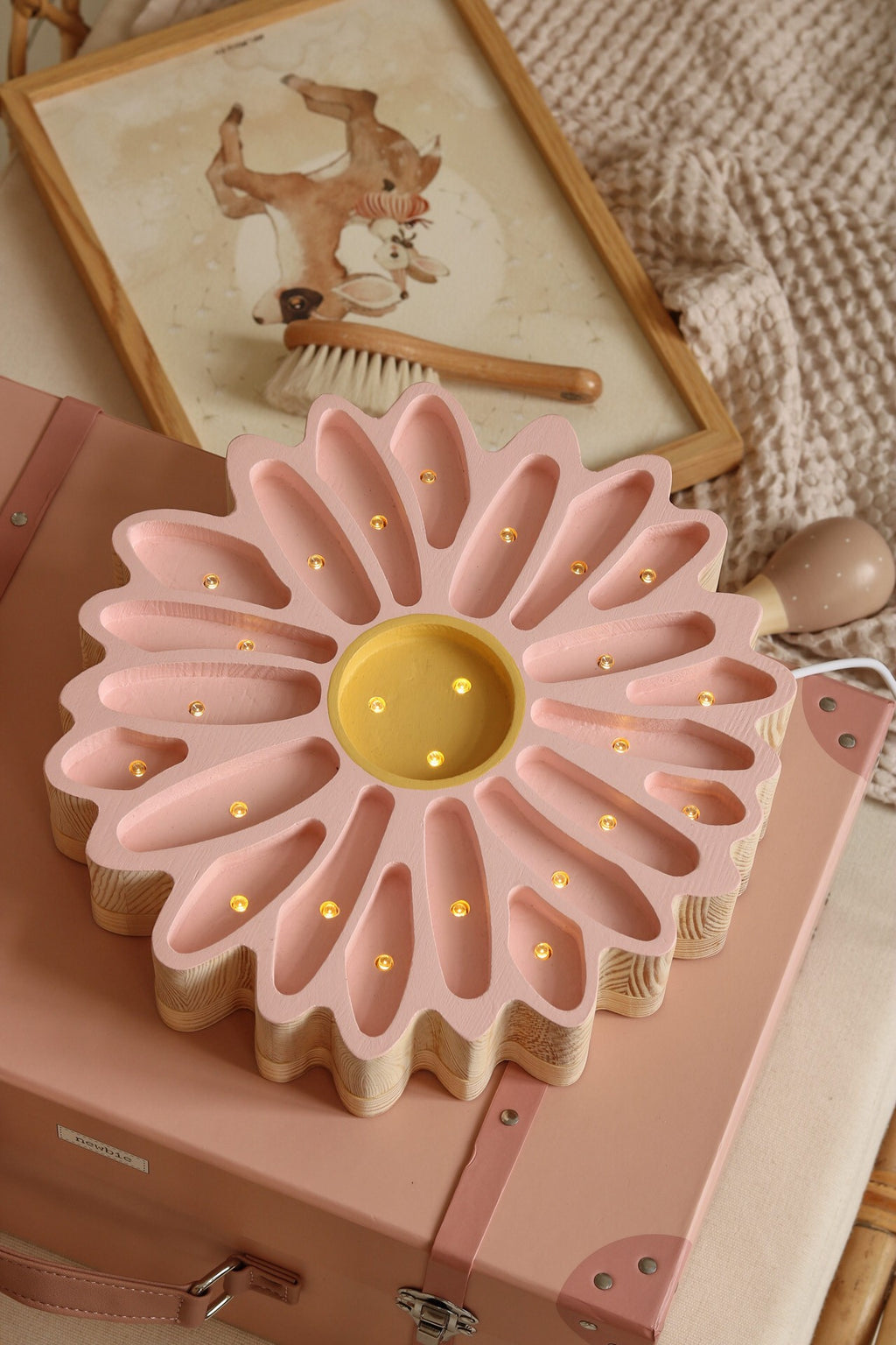 close-up of the daisy lamp's warm led glow on a pinewood nightstand