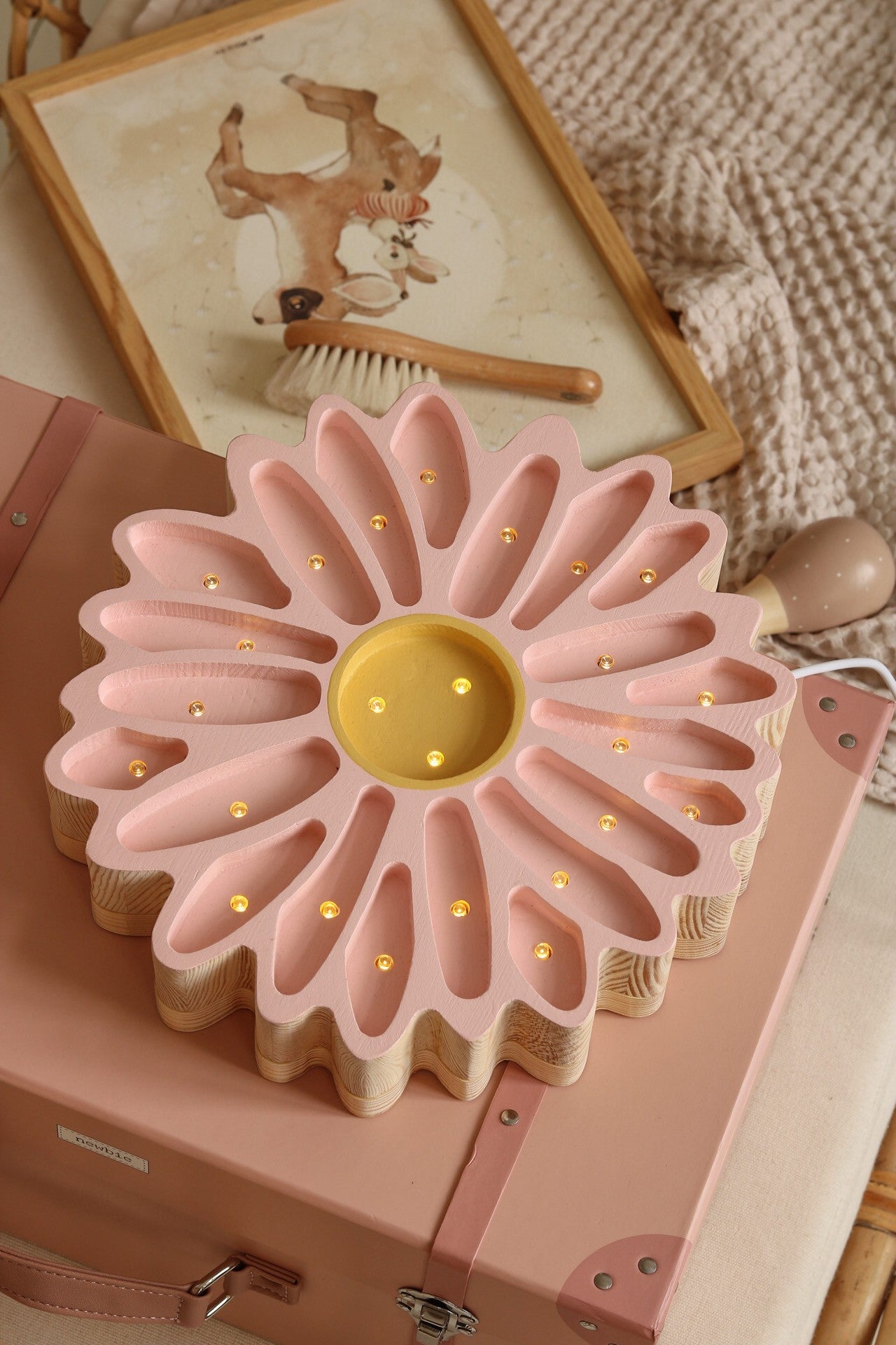close-up of the daisy lamp's warm led glow on a pinewood nightstand