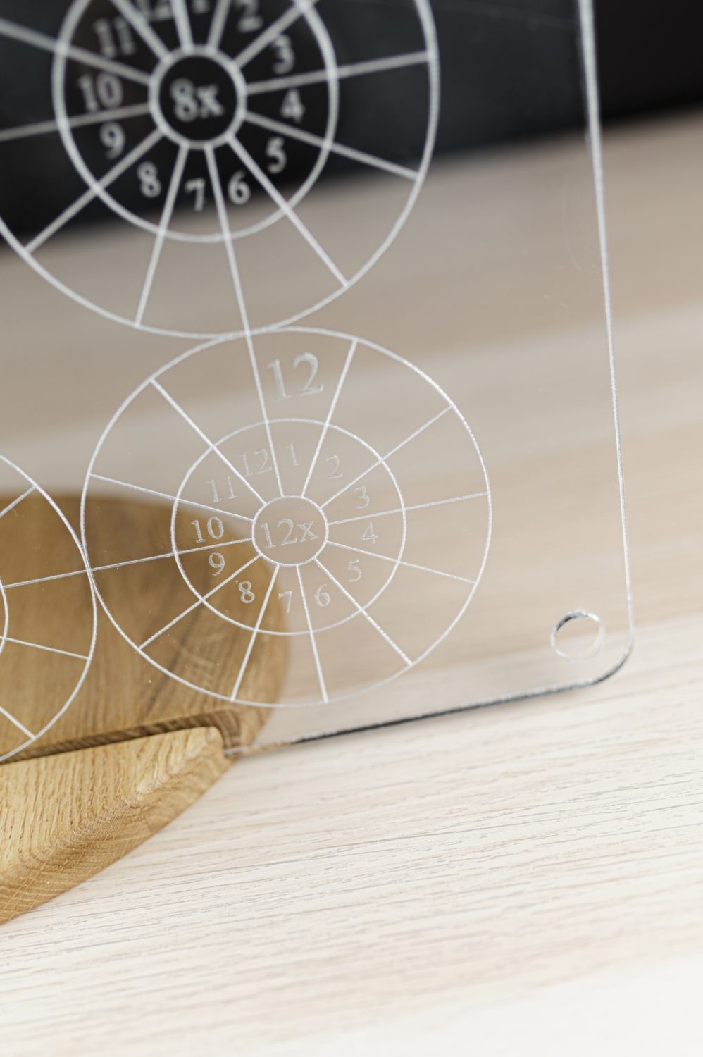 child's hand writing on the floating luula multiplication board with a colorful dry-erase marker