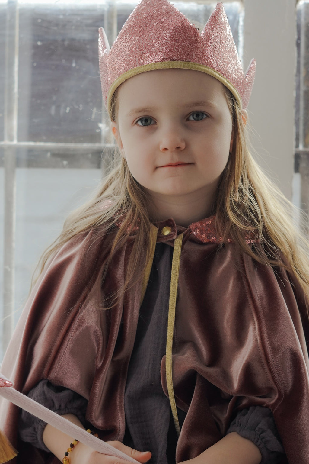 a child wearing the soft cosmic pearl magic cape, looking cozy and imaginative in gentle light