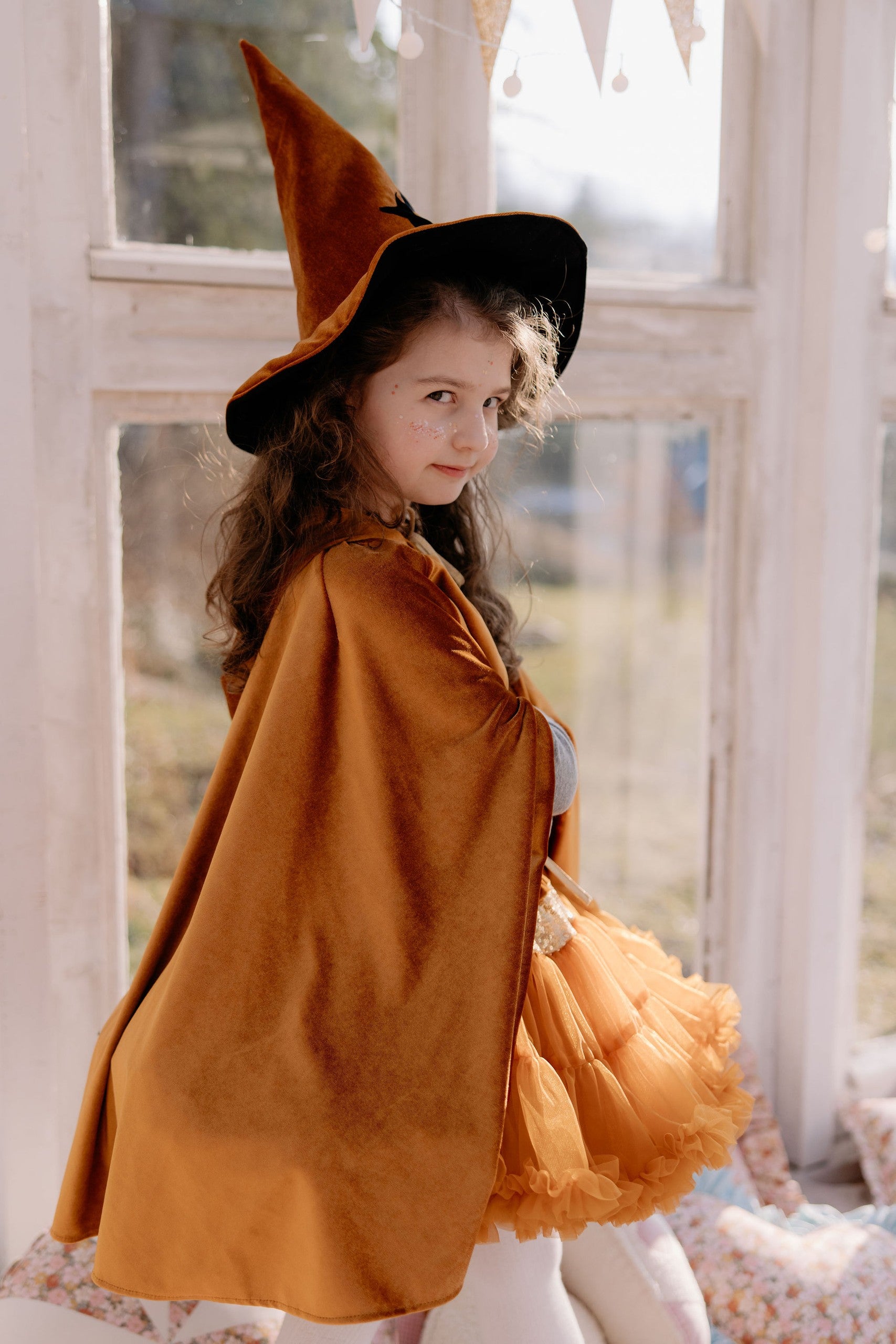 handmade golden velour cape for kids, shown in soft morning light on a wooden bench