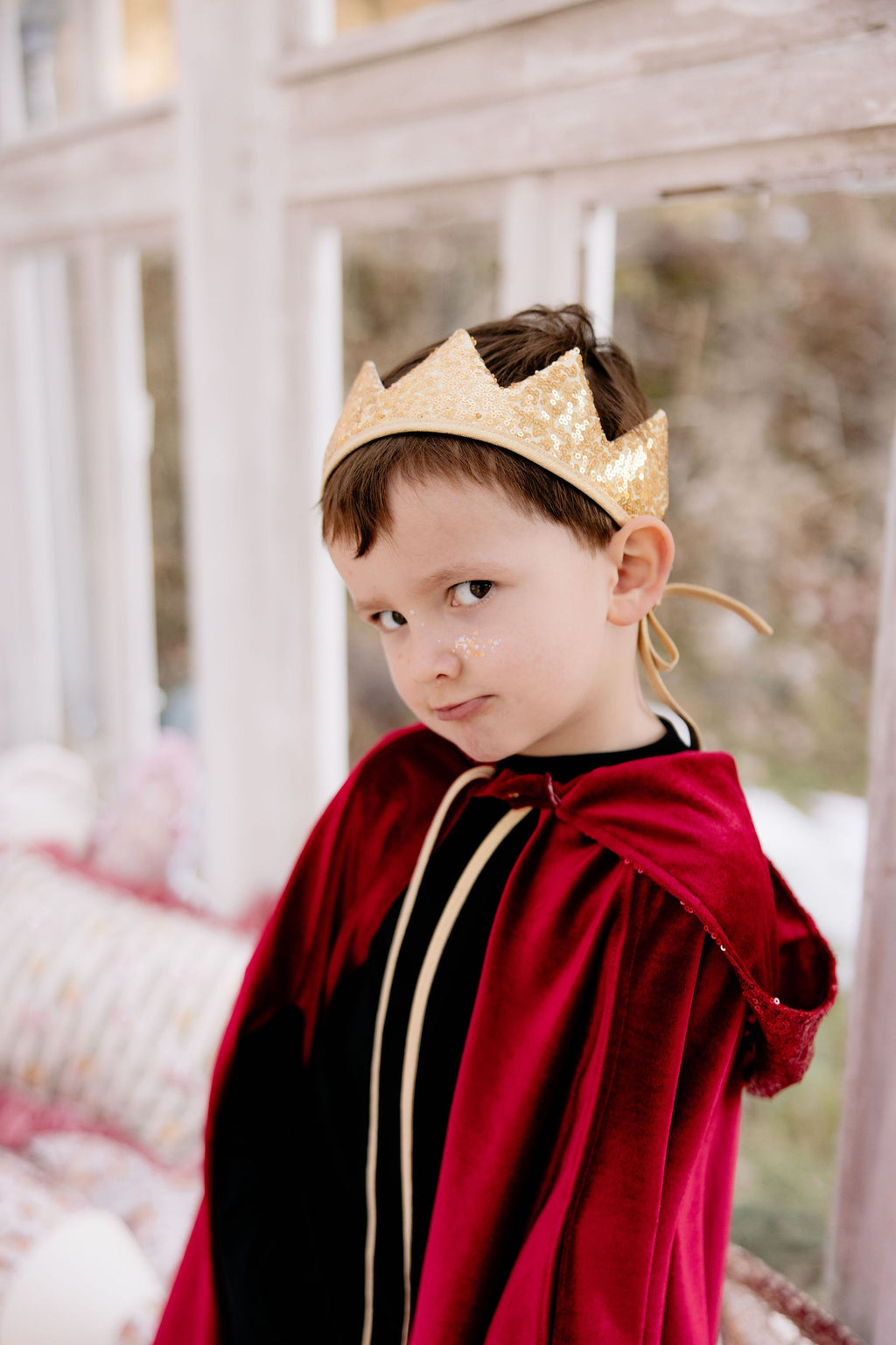soft red velour magic cape with a deep hood, gently draped over a child’s shoulders for cozy fairy tale adventures