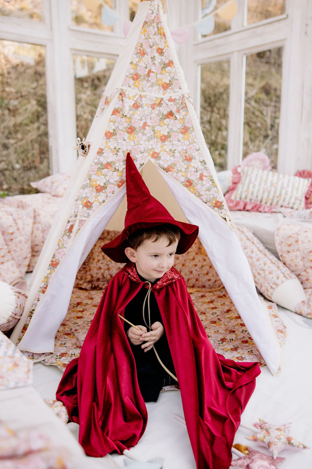 red riding hood cape with hand holes for active play, shown draped over a wooden chair in natural light