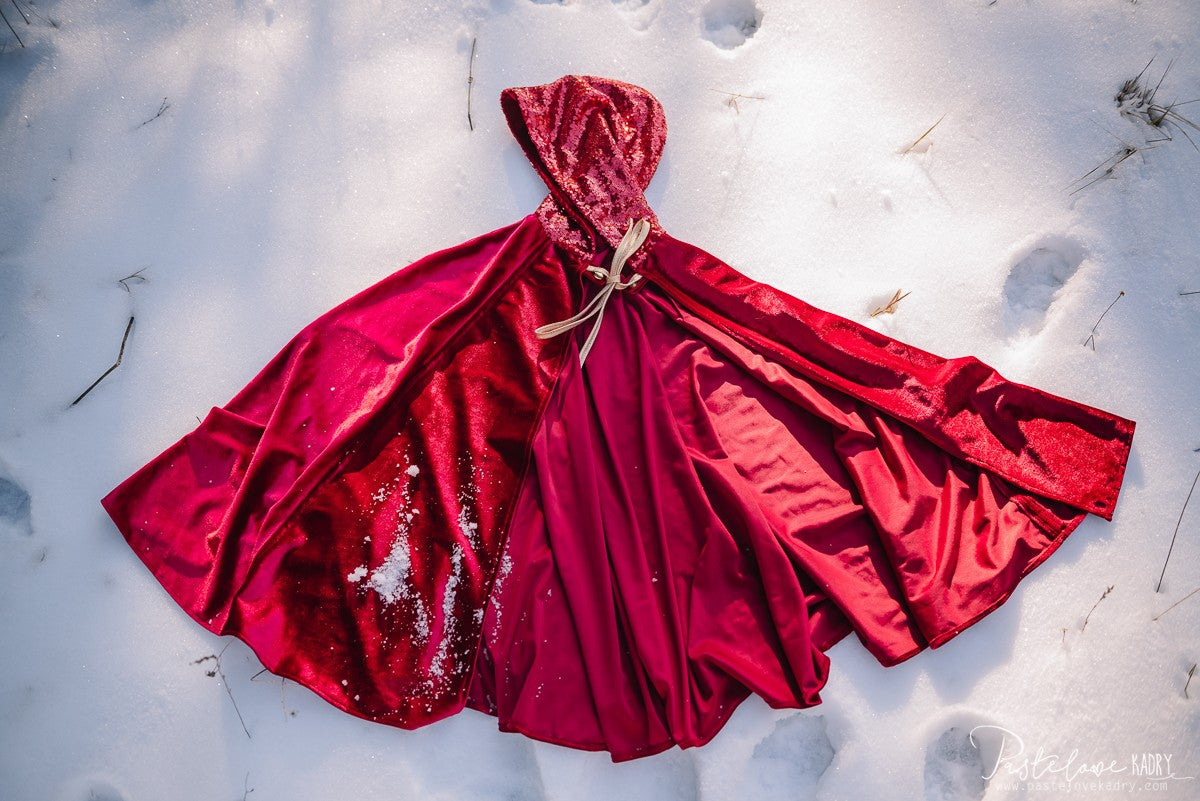 red riding hood magic cape swirling in golden sunlight, hood up and velour shimmering for fairy tale adventures