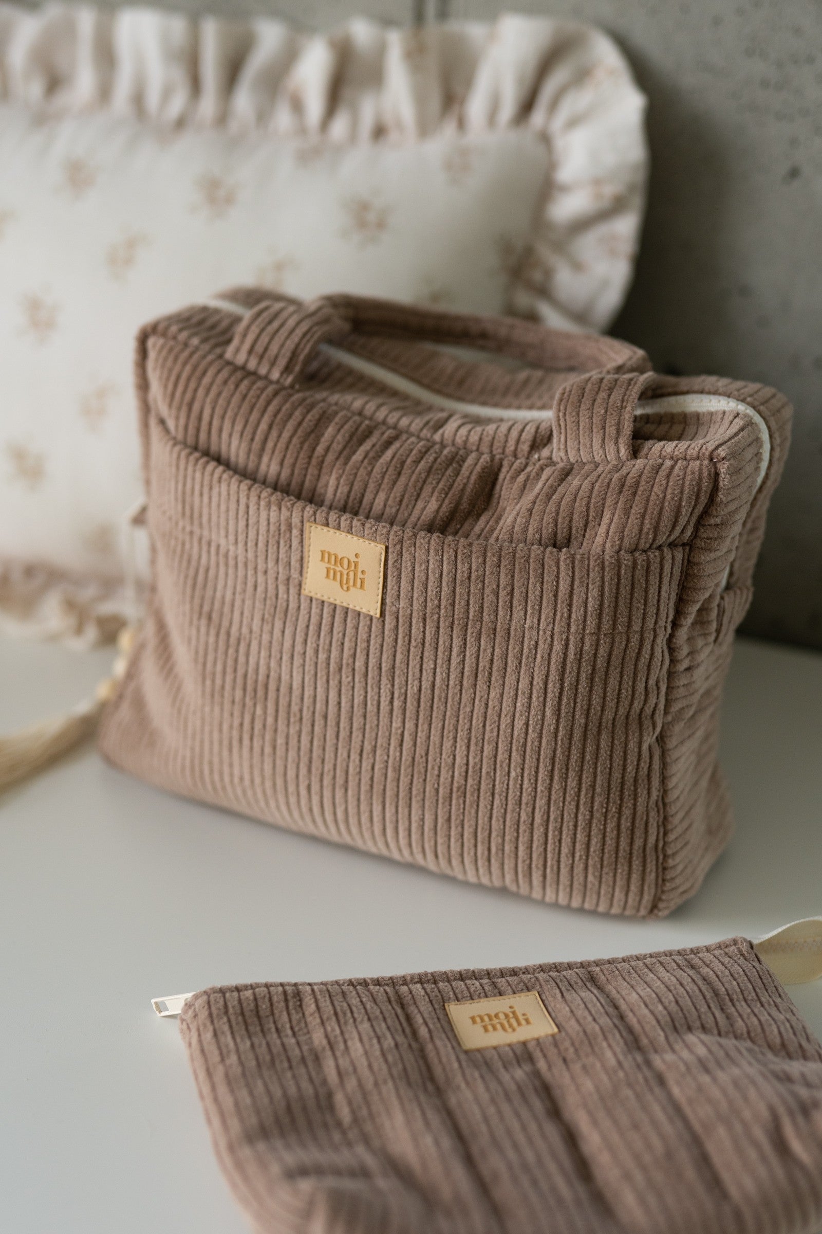 a chic latte-colored cotton makeup bag set of two, open on a rustic wooden table