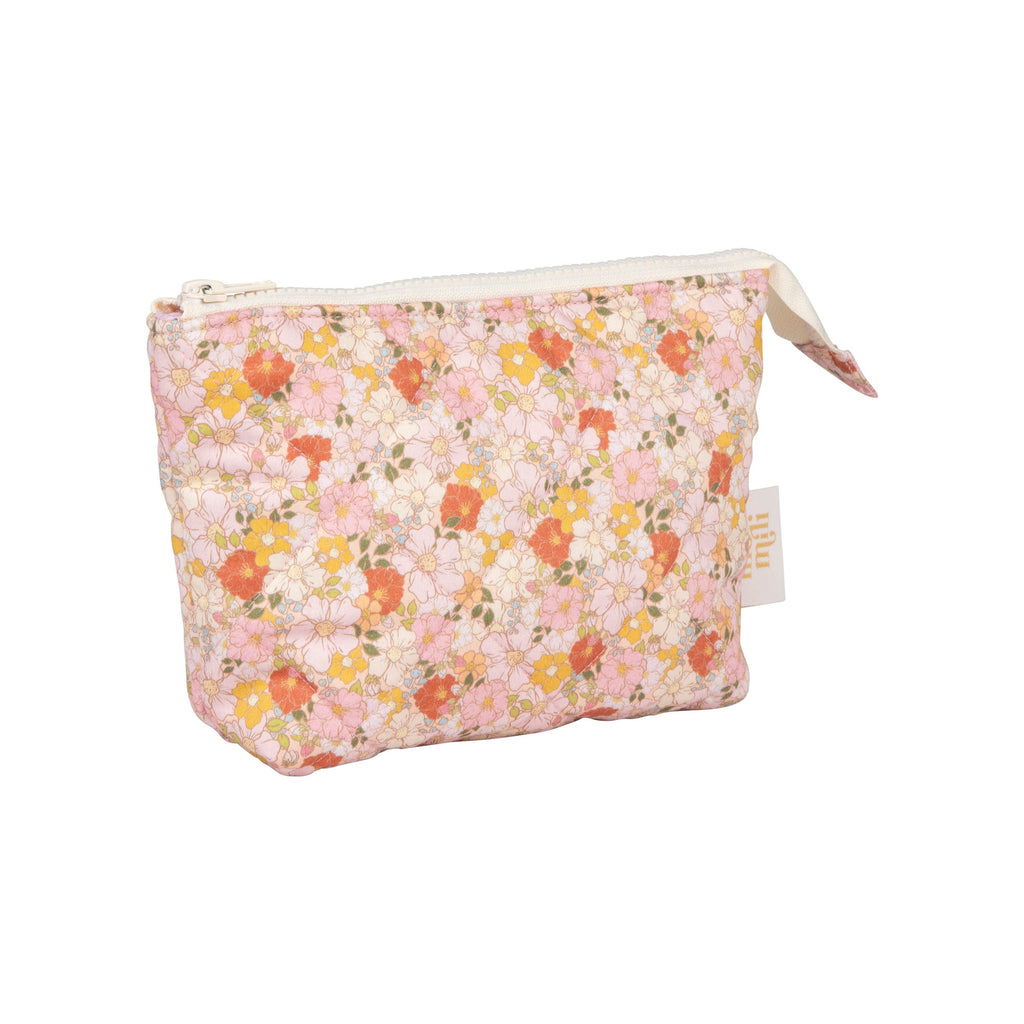 set of two spring garden makeup bags open on a rustic wooden table