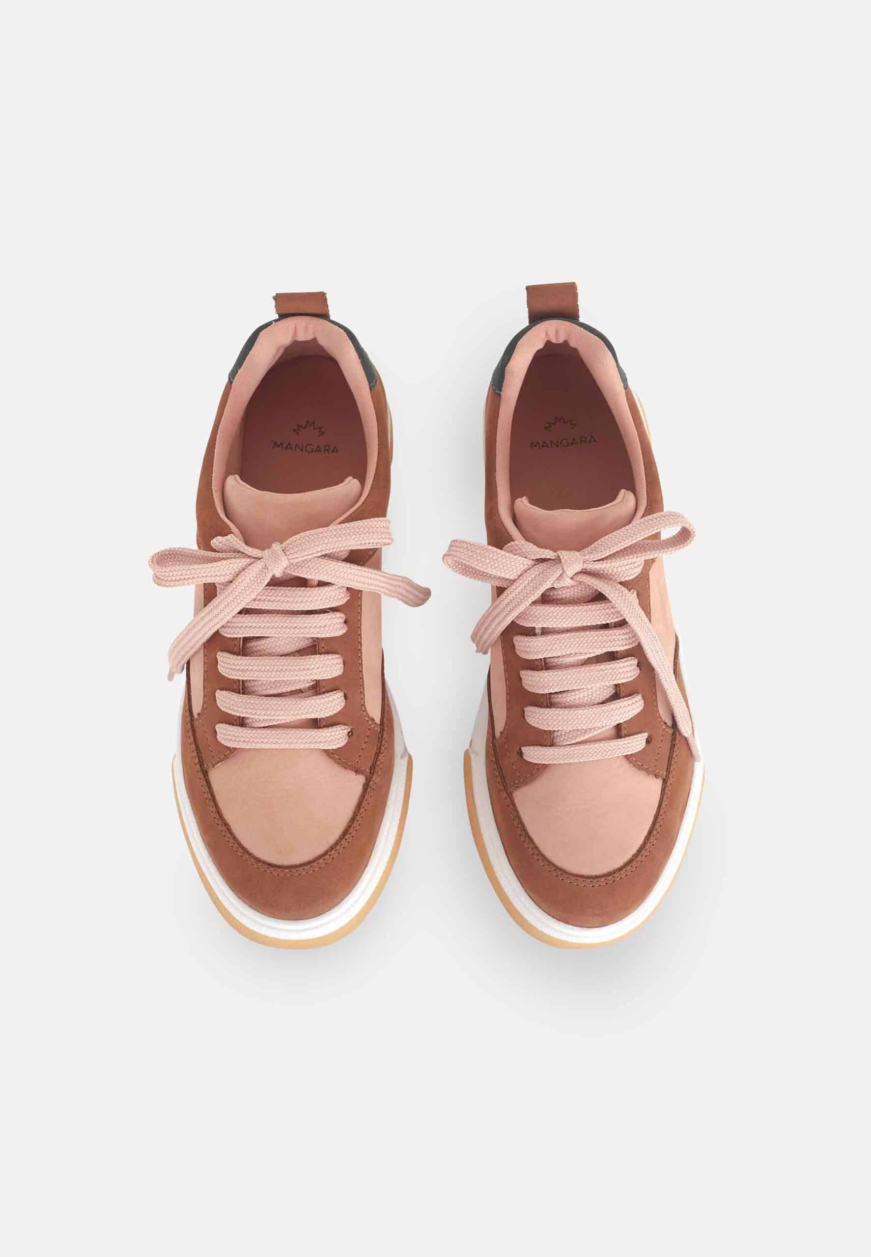 playful beige andira sneakers on a sunny day, showing off their unique orange and brown leather details