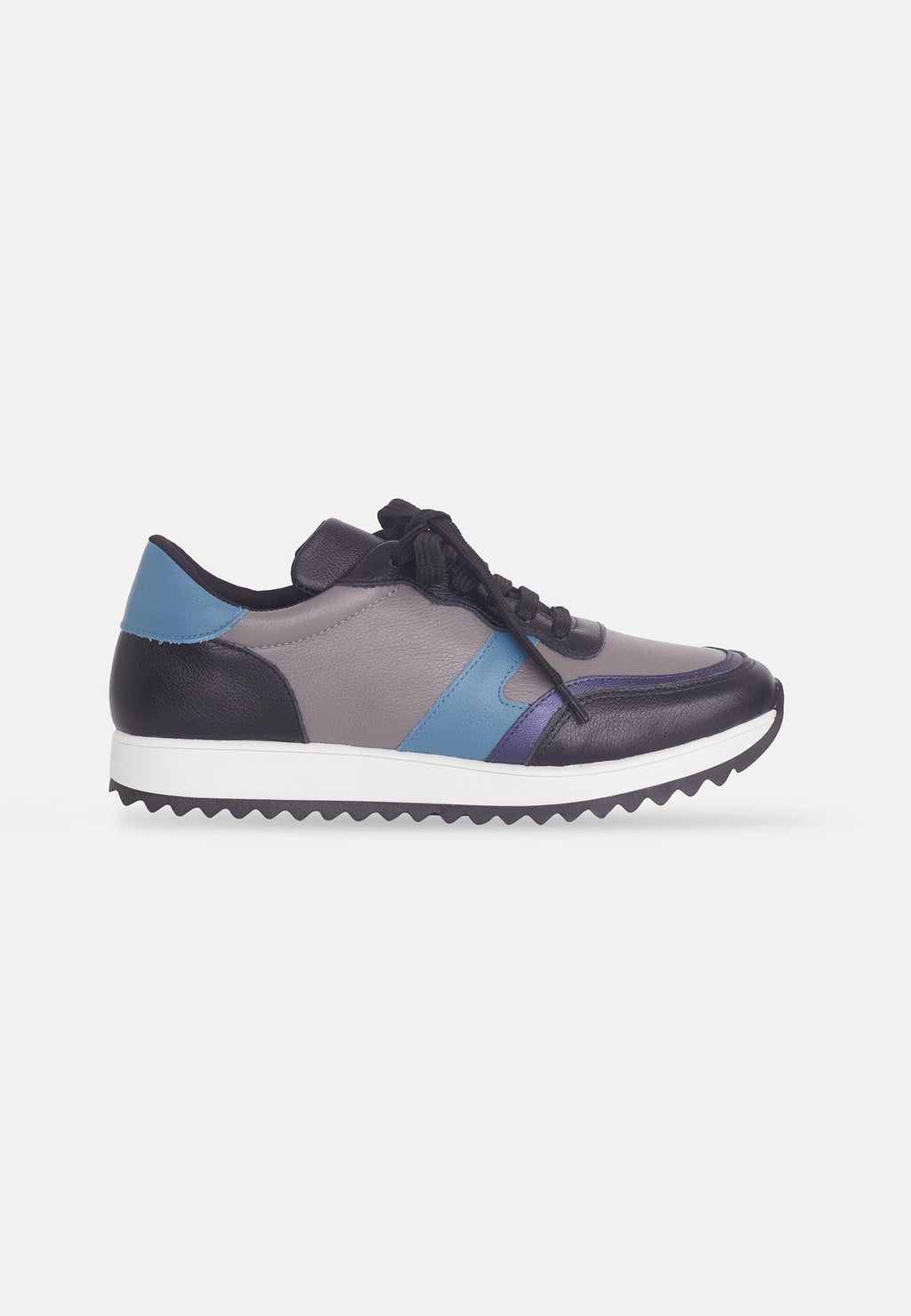 confident woman in mangara buriri polished leather sneakers with grey and blue accents on city street