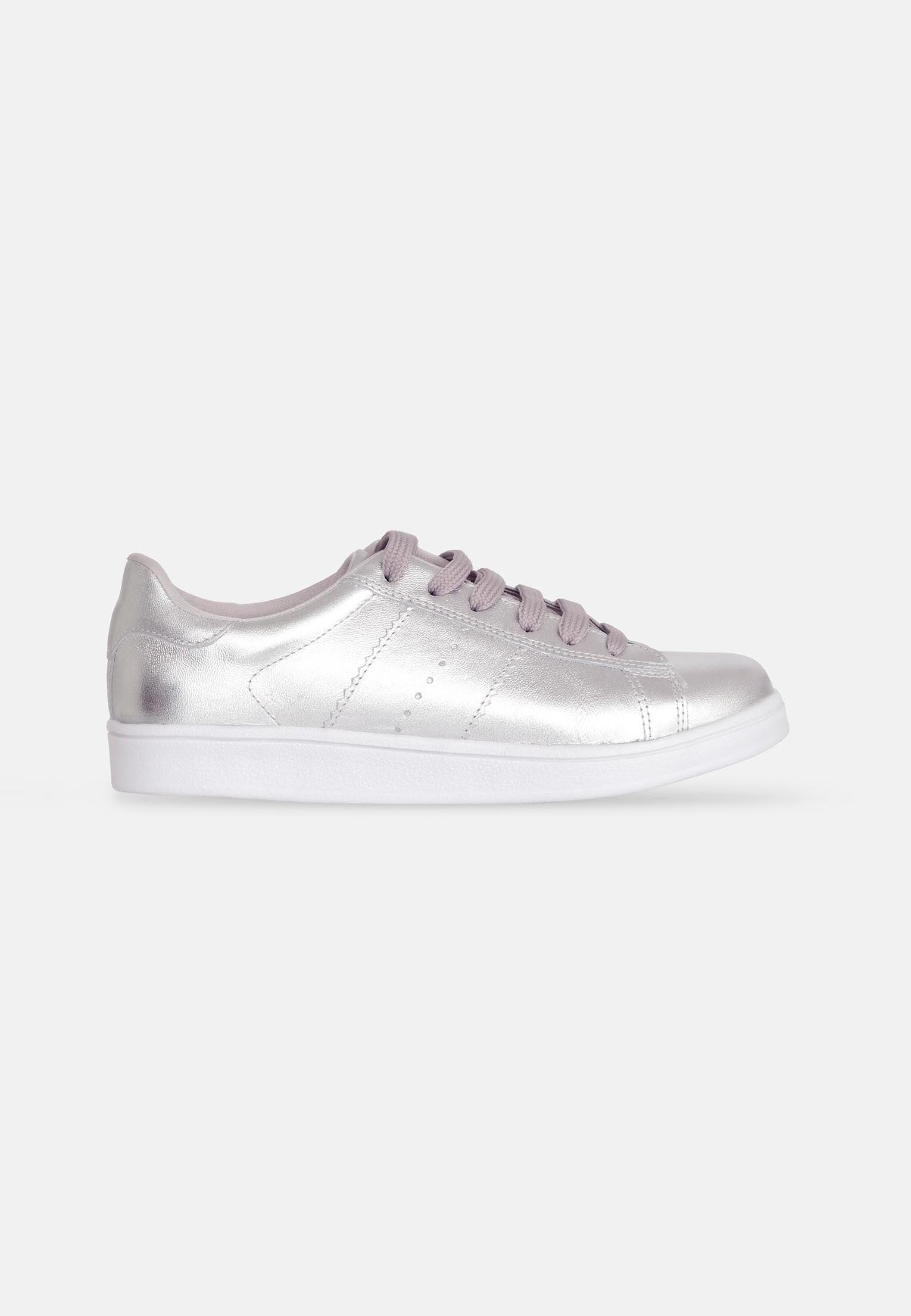confident woman's metallic silver leather sneakers with bold shine and modern lace-up design
