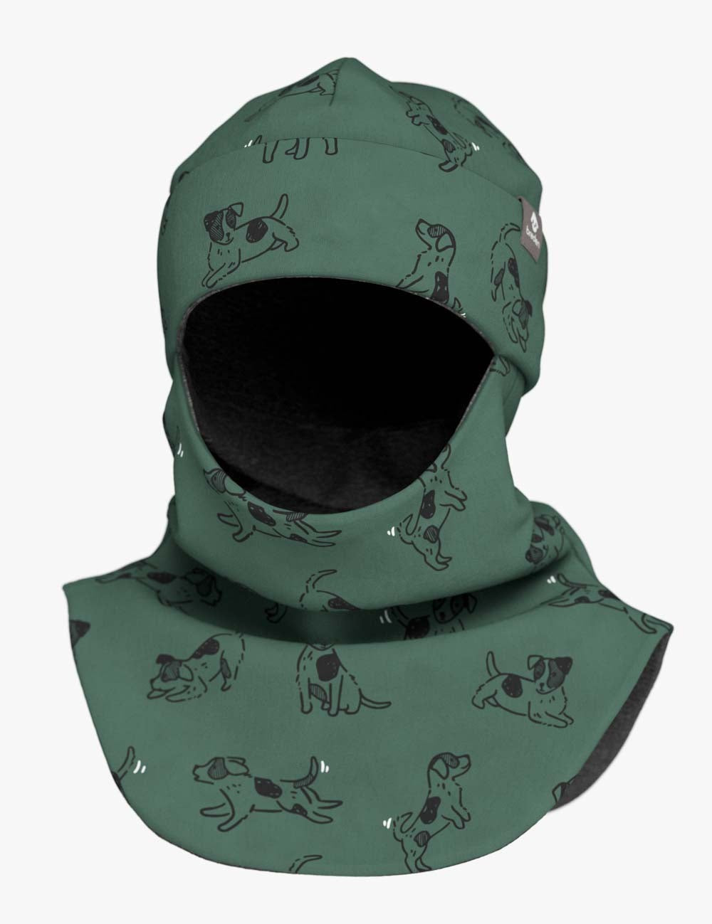 a child laughing in a green dog-print balaclava during a sunny winter garden playtime