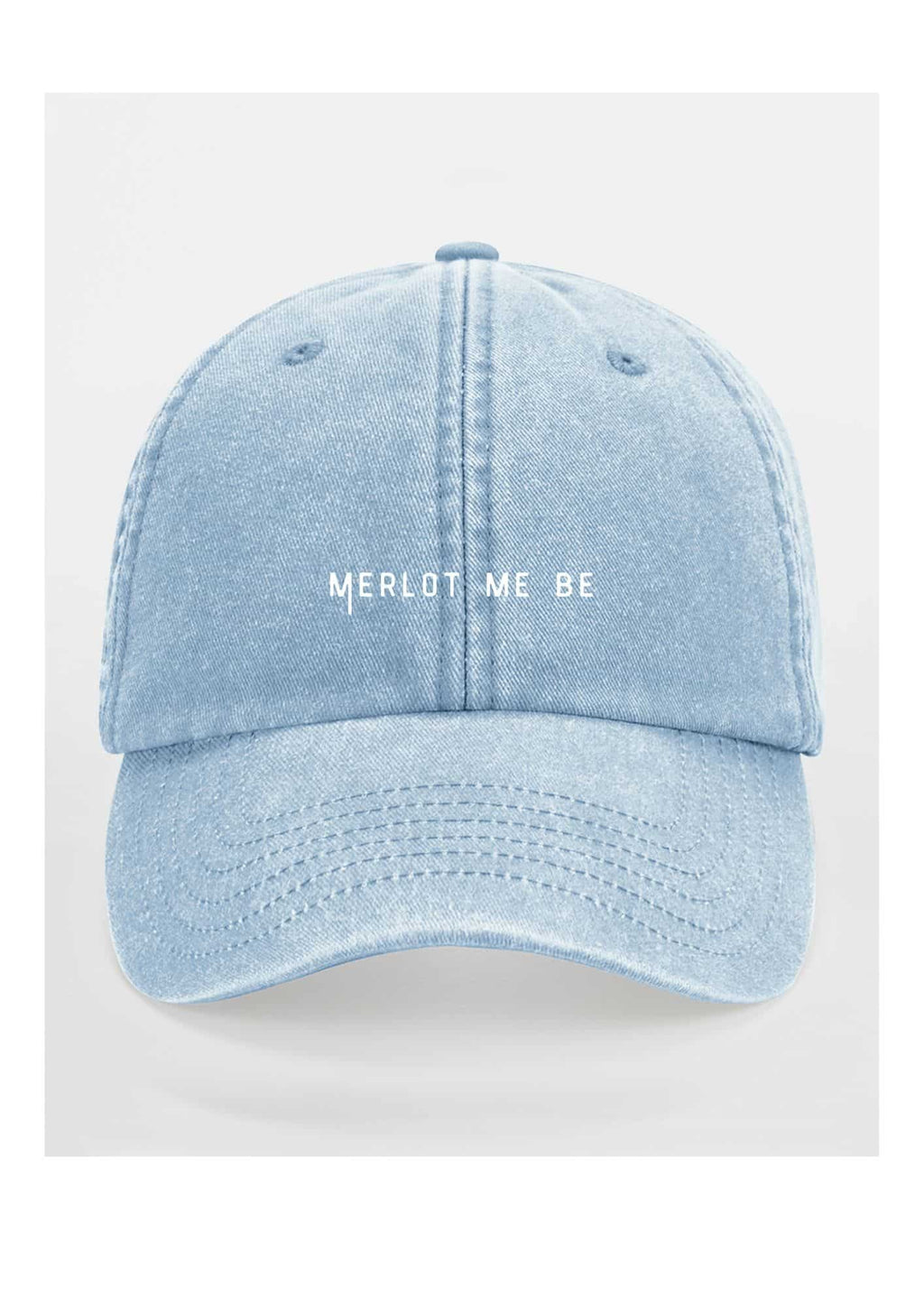 a soft cotton merlot me be cap resting on a cozy textured blanket in warm light