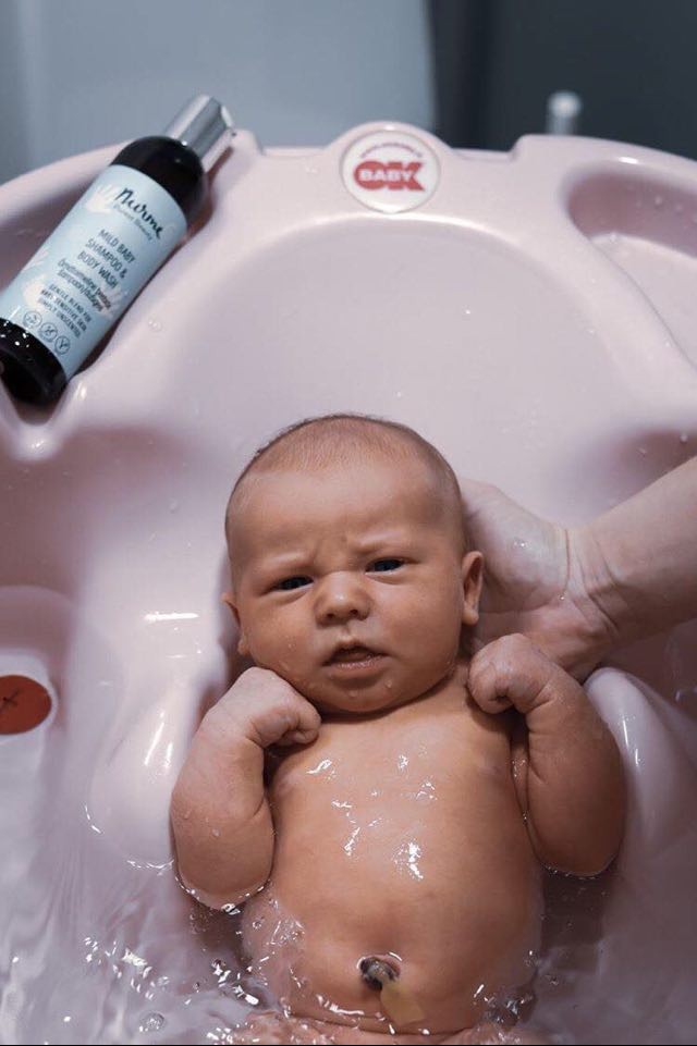 a soft-focus shot of nurme's gentle baby shampoo and body wash bottle, bathed in warm morning light